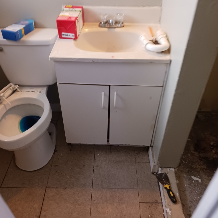 A bathroom with a toilet and a sink with a box on top of it