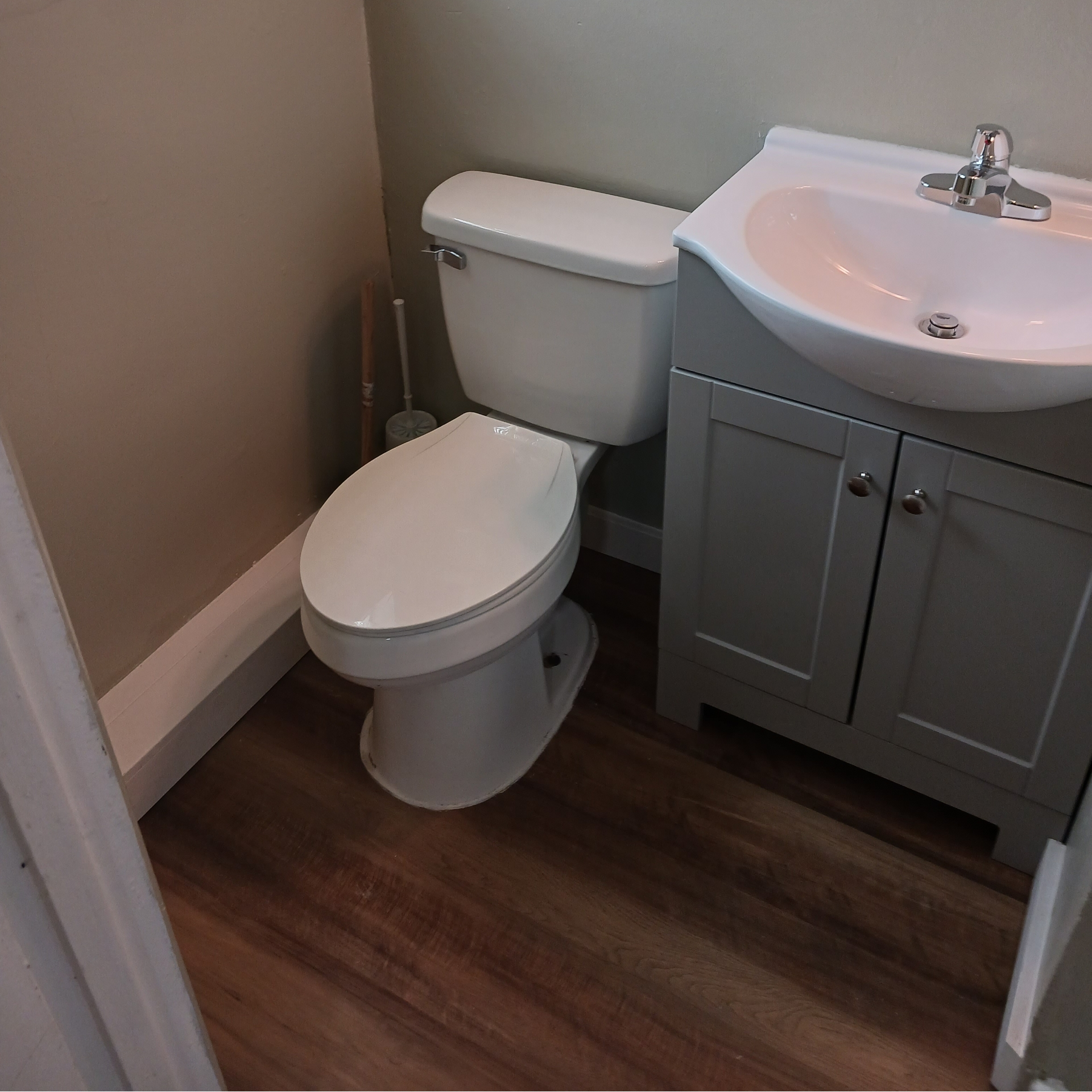 A bathroom with a toilet , sink and cabinets