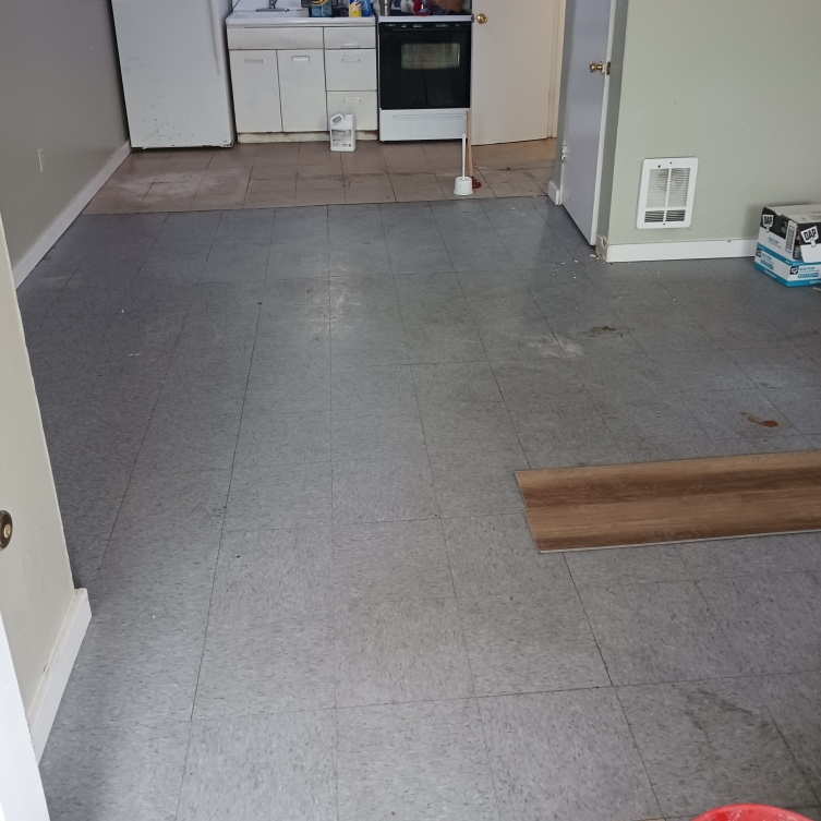 A kitchen with a gray tile floor and a stove