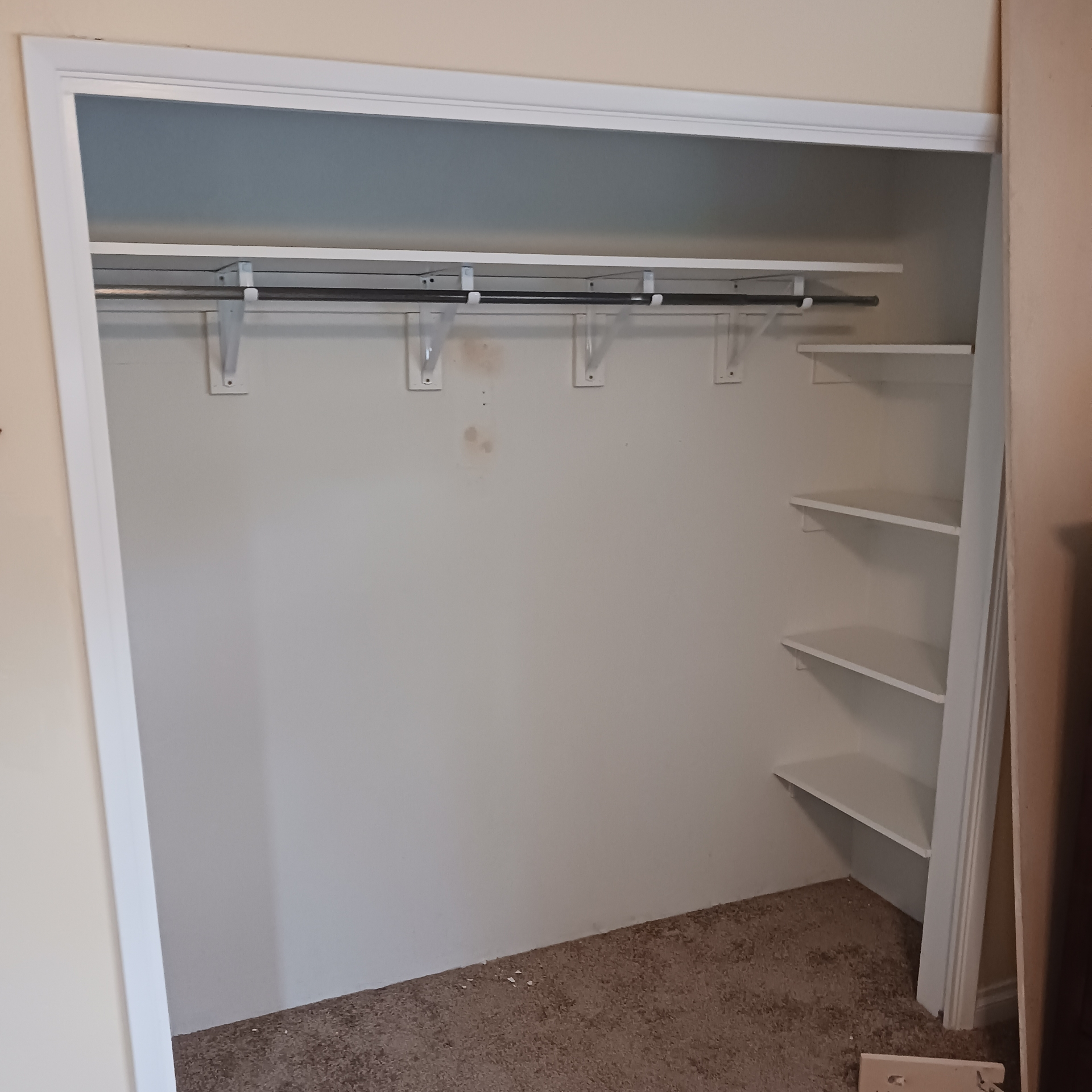 An empty closet with shelves and clothes racks