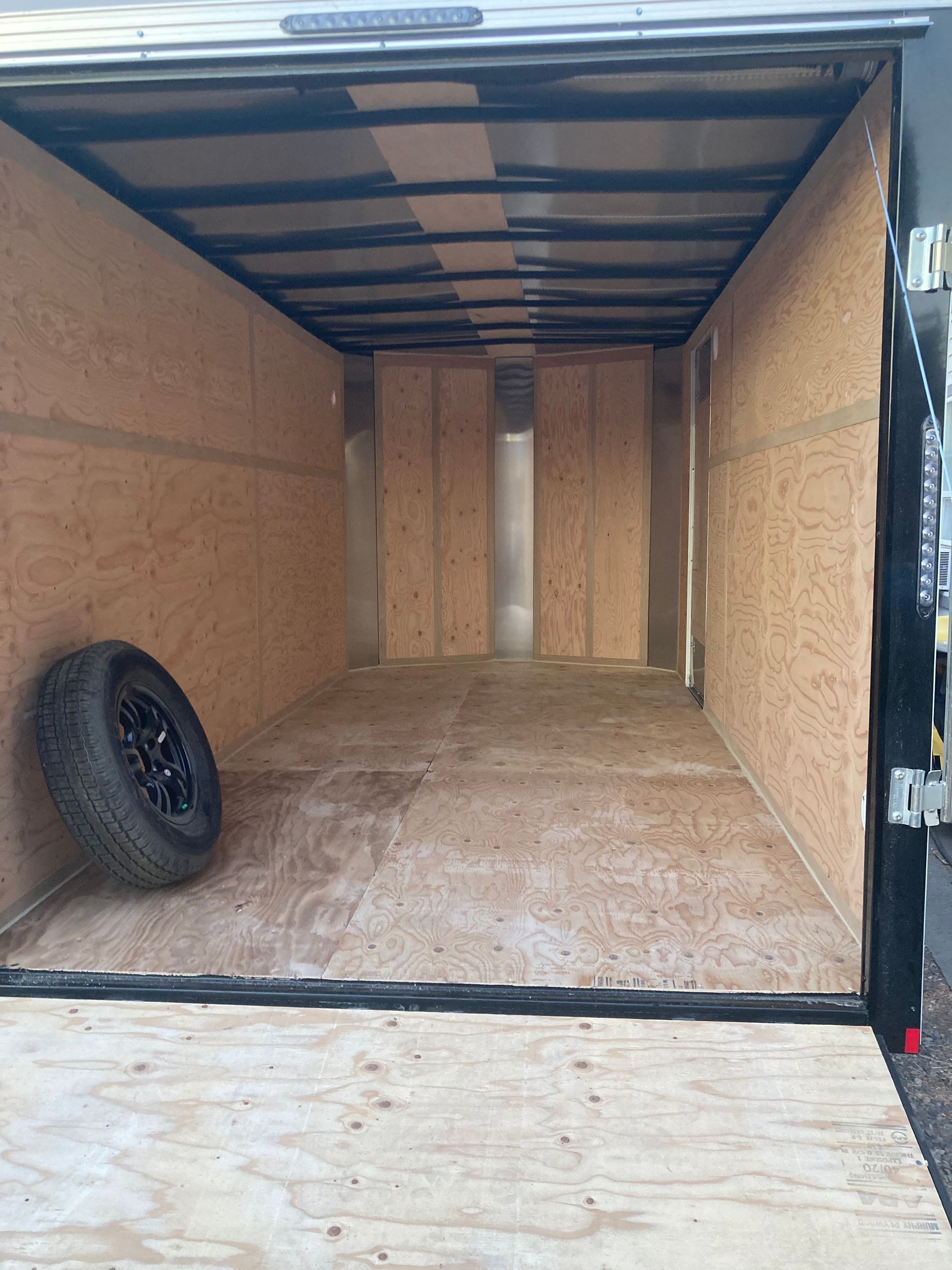 An empty trailer with a tire in the back