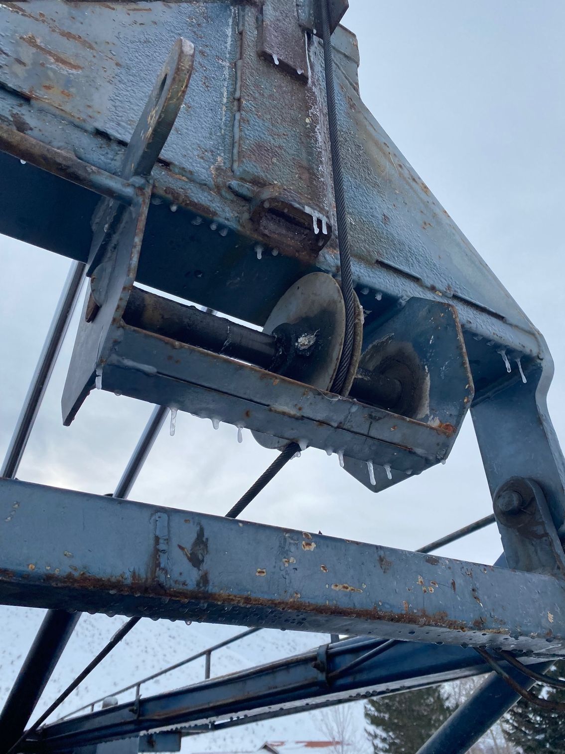 A close up of a metal structure with a rope hanging from it.