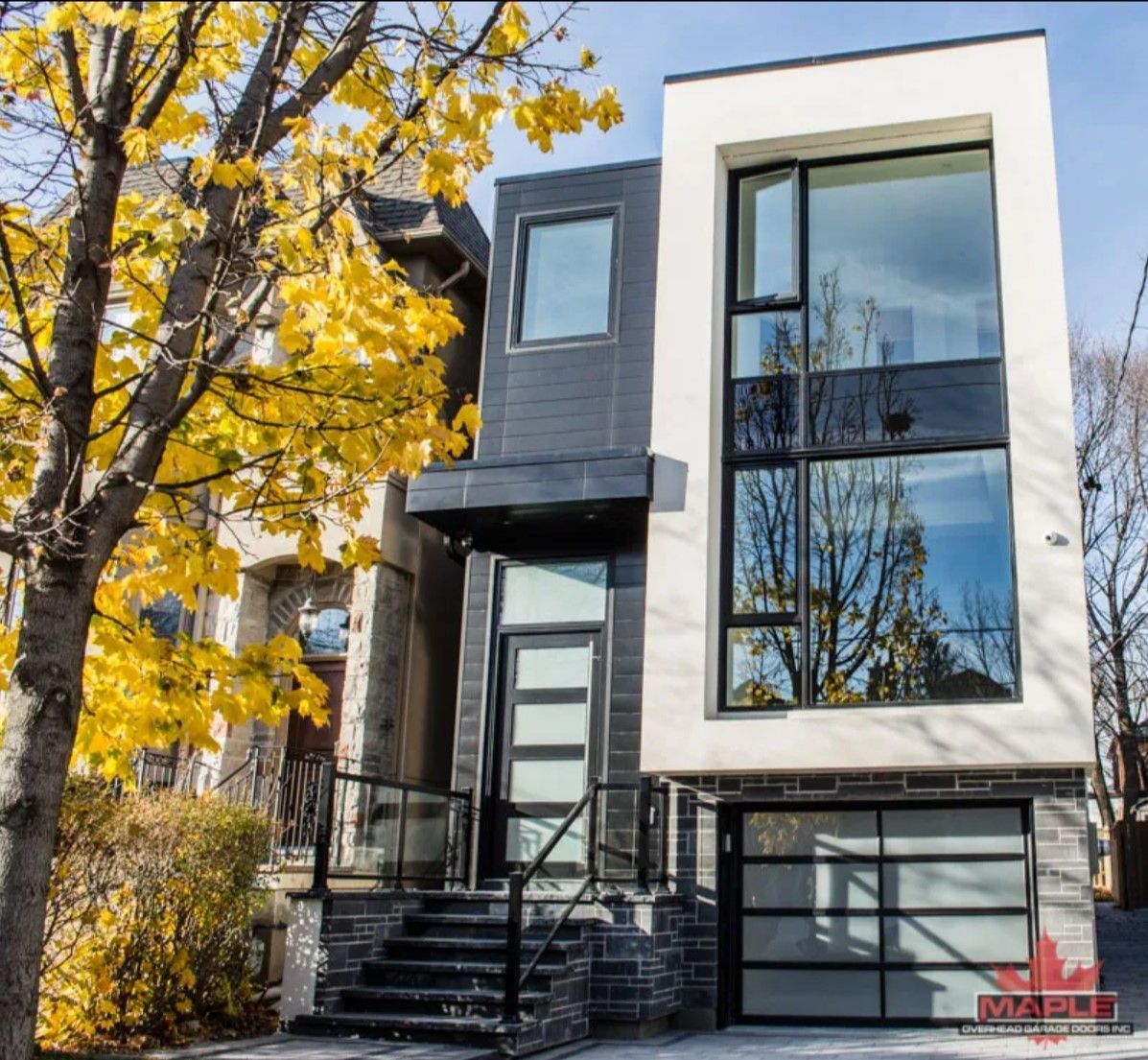 A house with a lot of windows and a tree in front of it