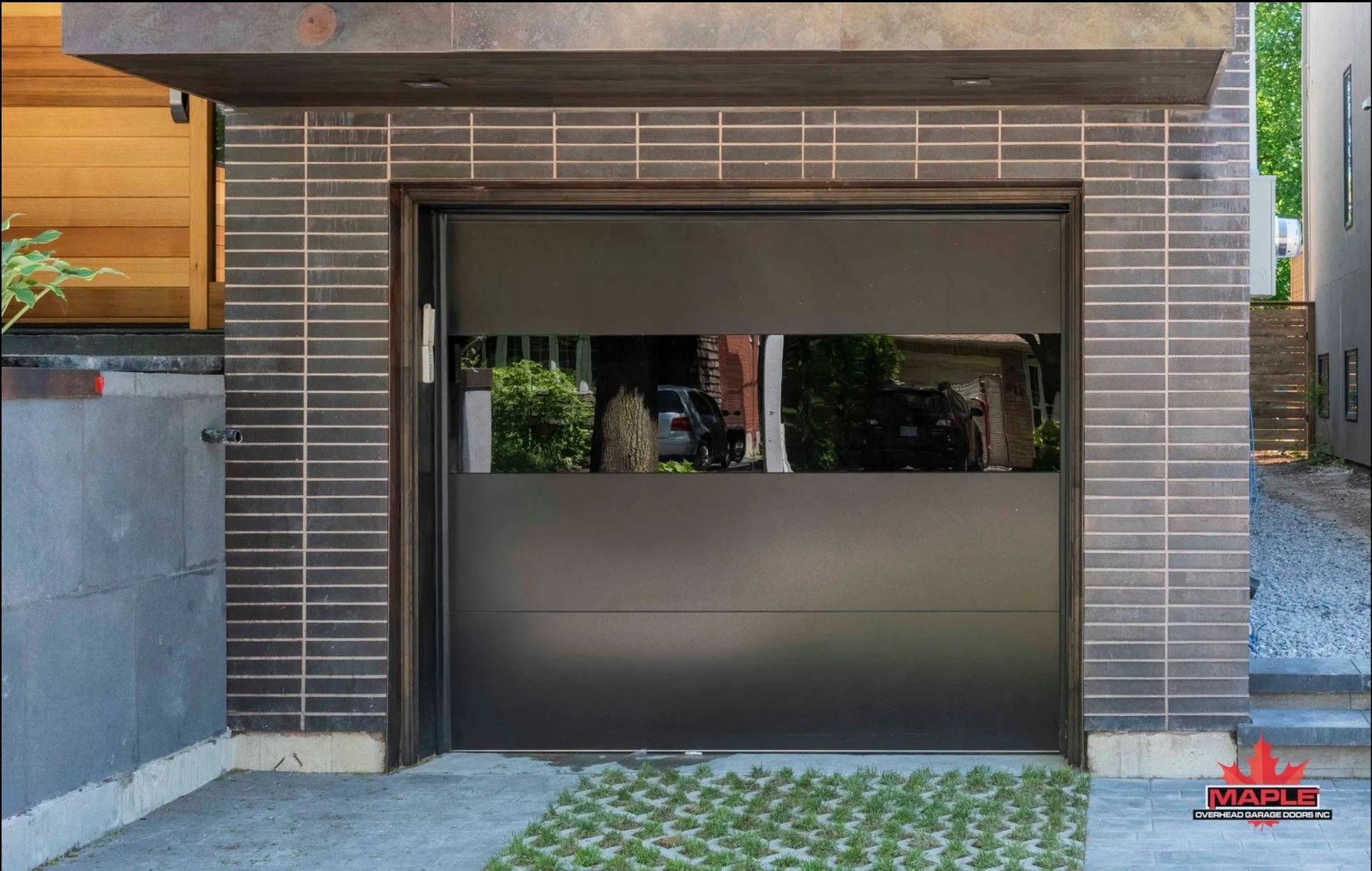 A black garage door with a reflection of a car in it