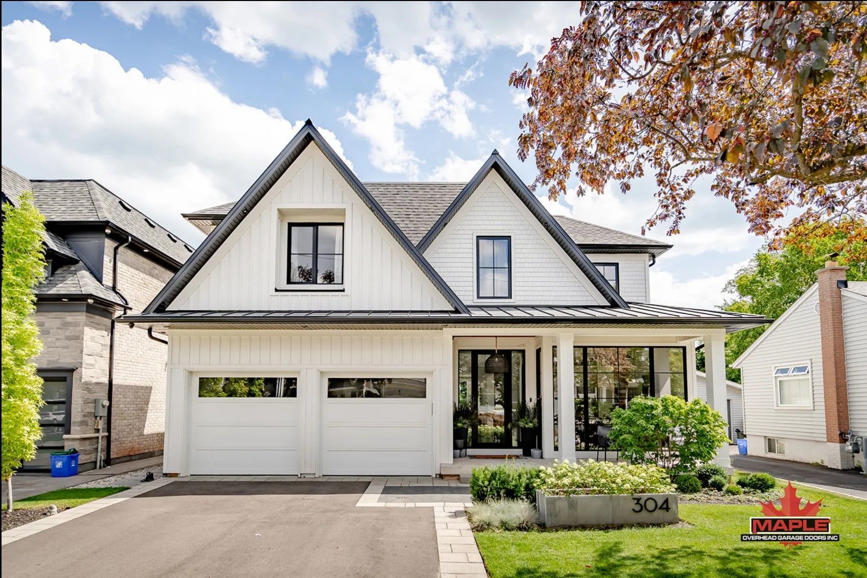 A large white house with a black roof is for sale.