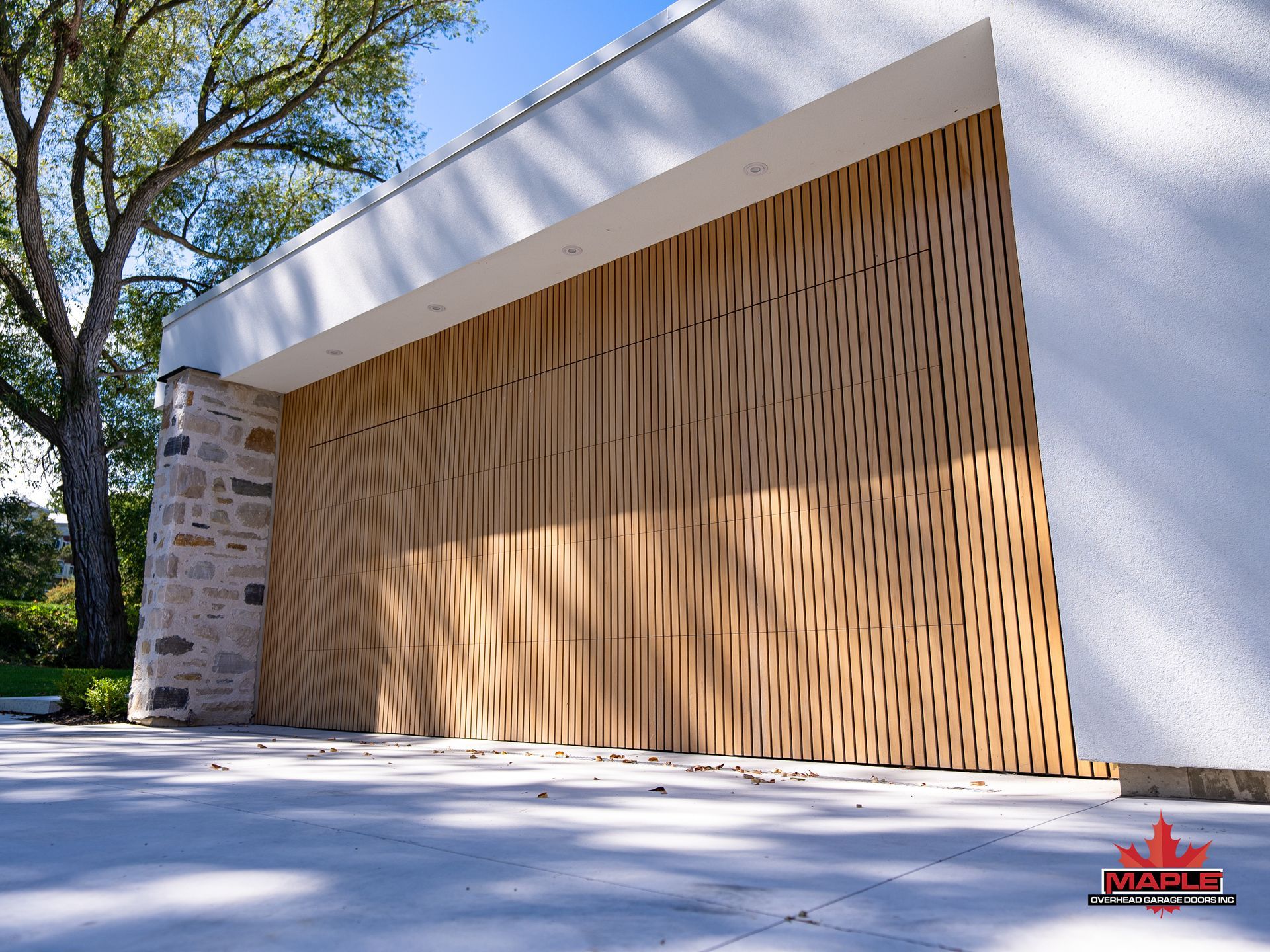 A white building with a wooden wall and a tree in the background