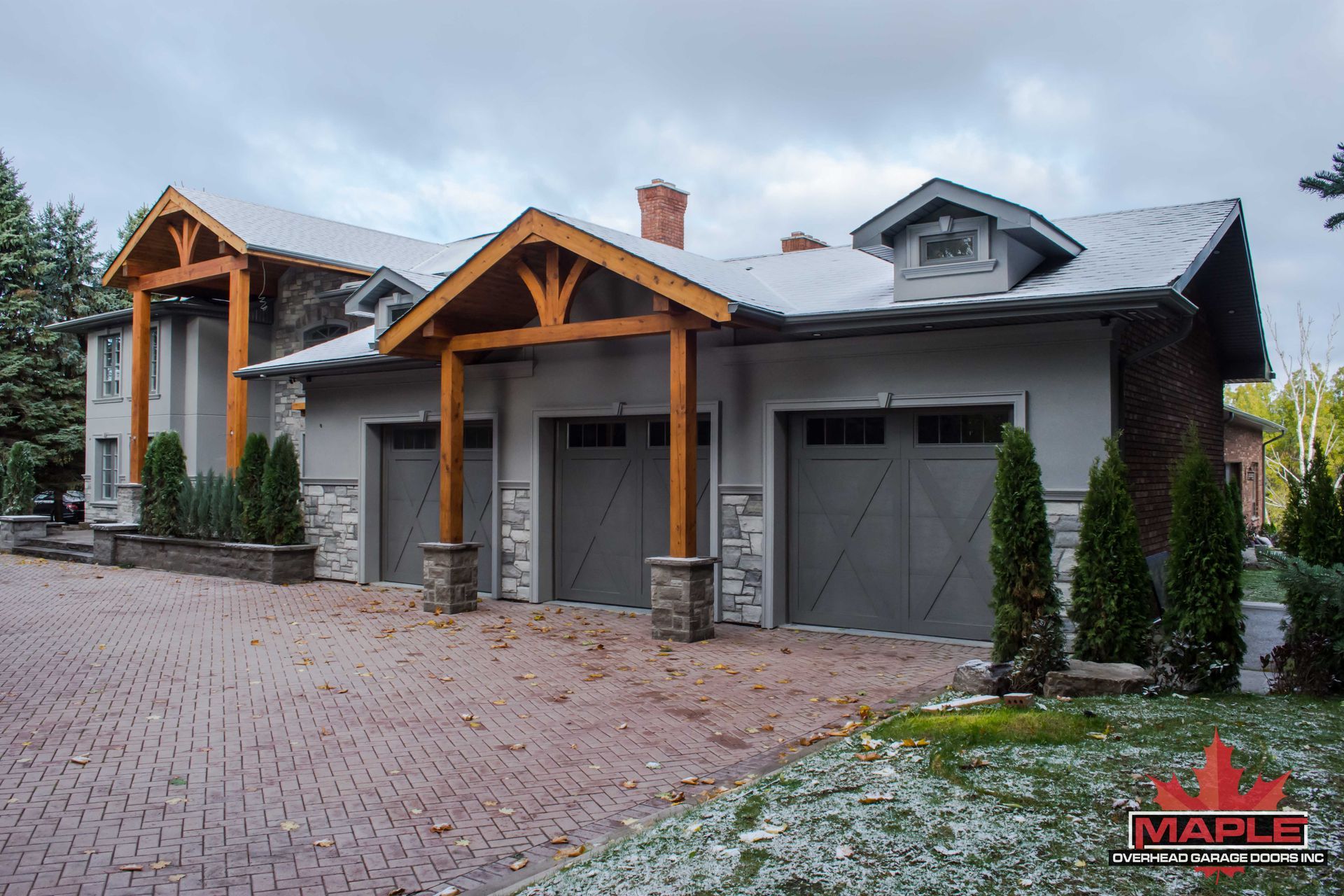 A large house with a lot of garage doors and trees in front of it.