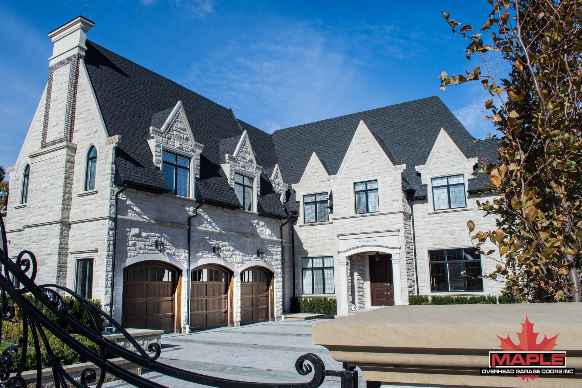 A large white brick house with a black roof