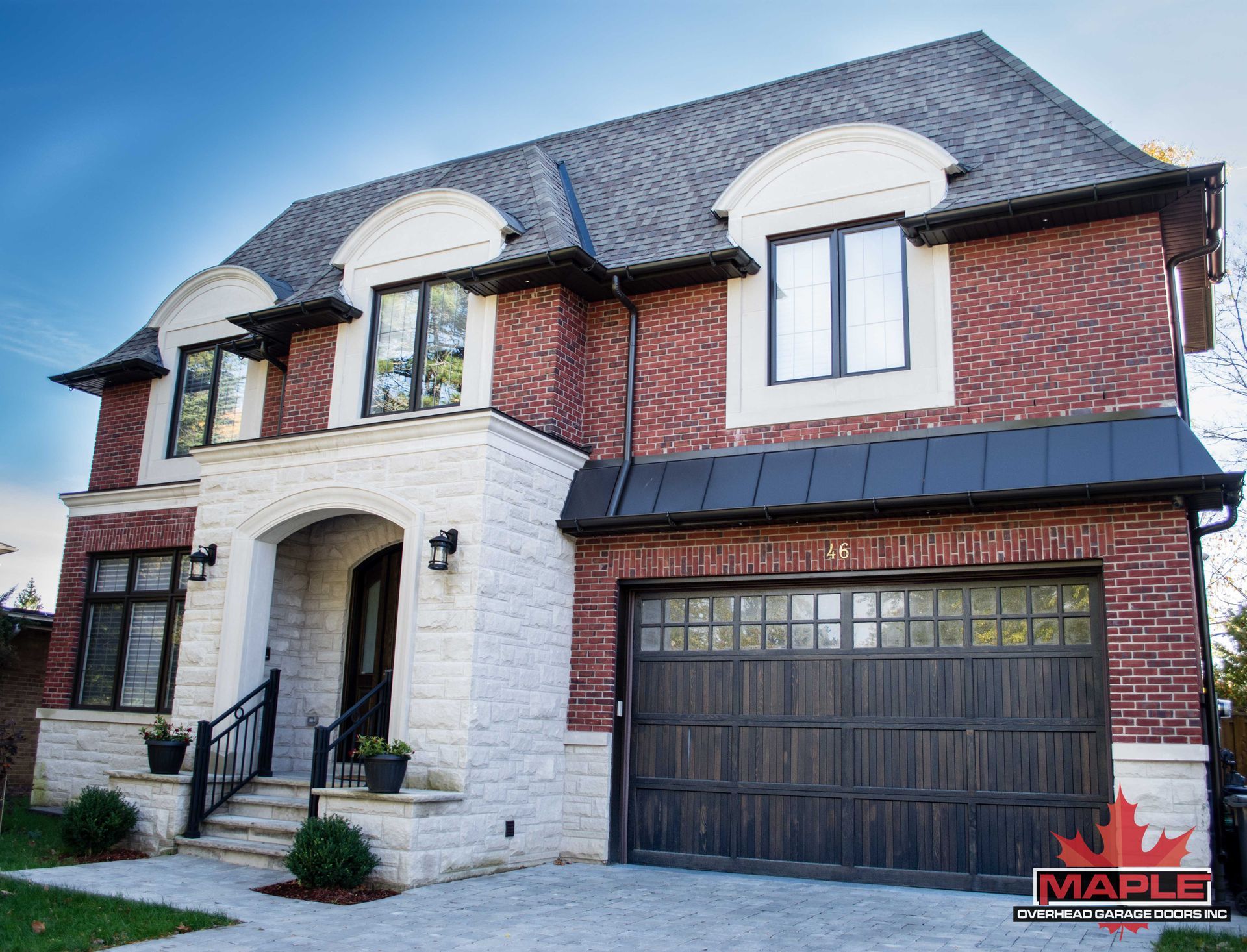 A large brick house with a black garage door