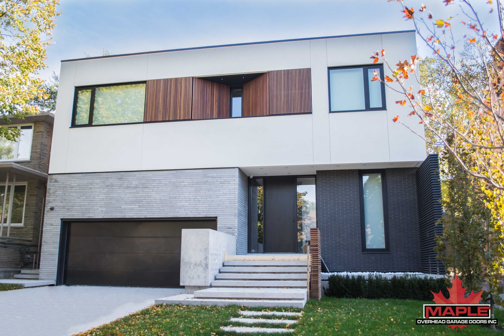 A modern house with a black garage door and stairs