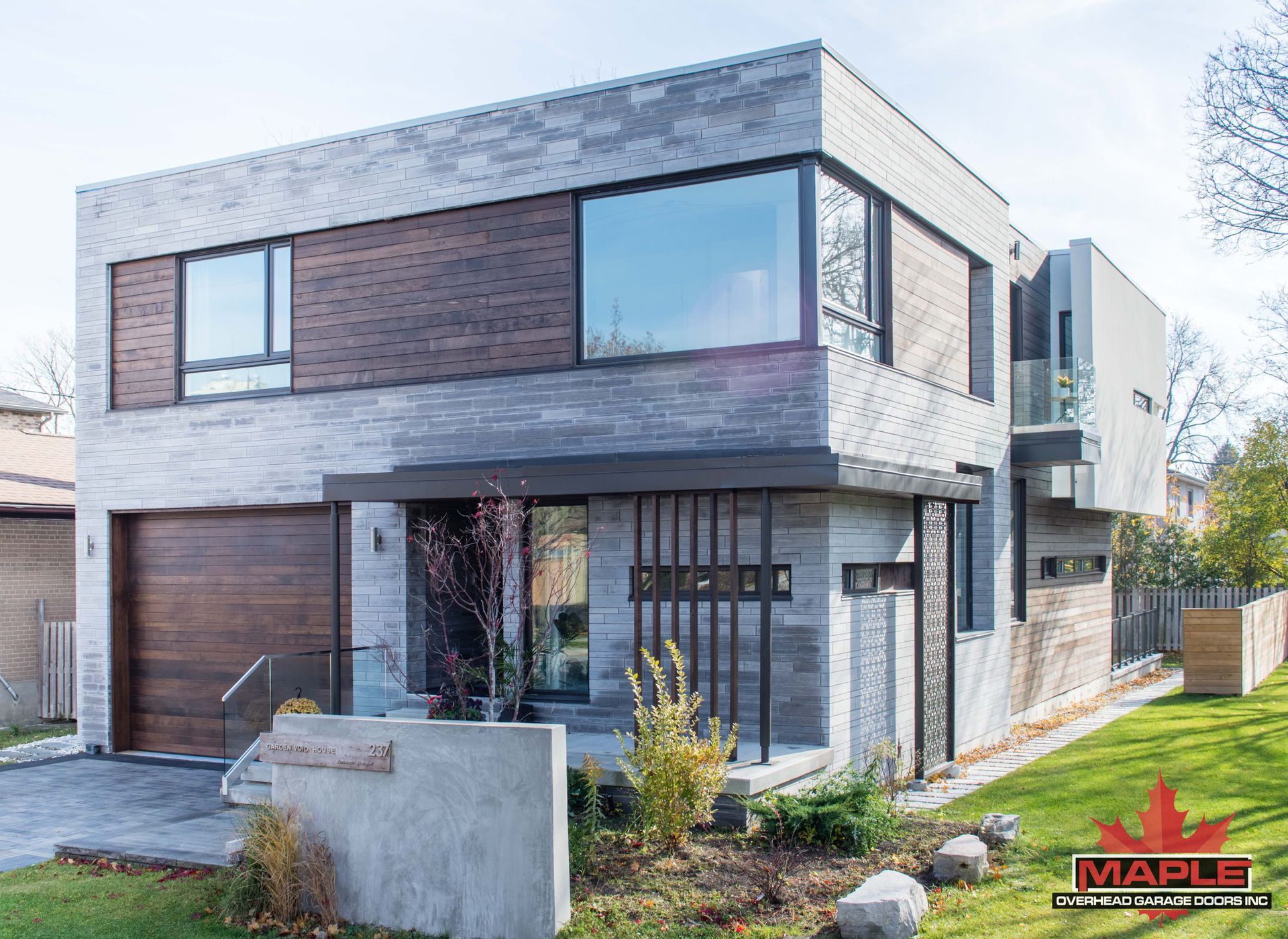 A modern house with a large garage and a lot of windows.