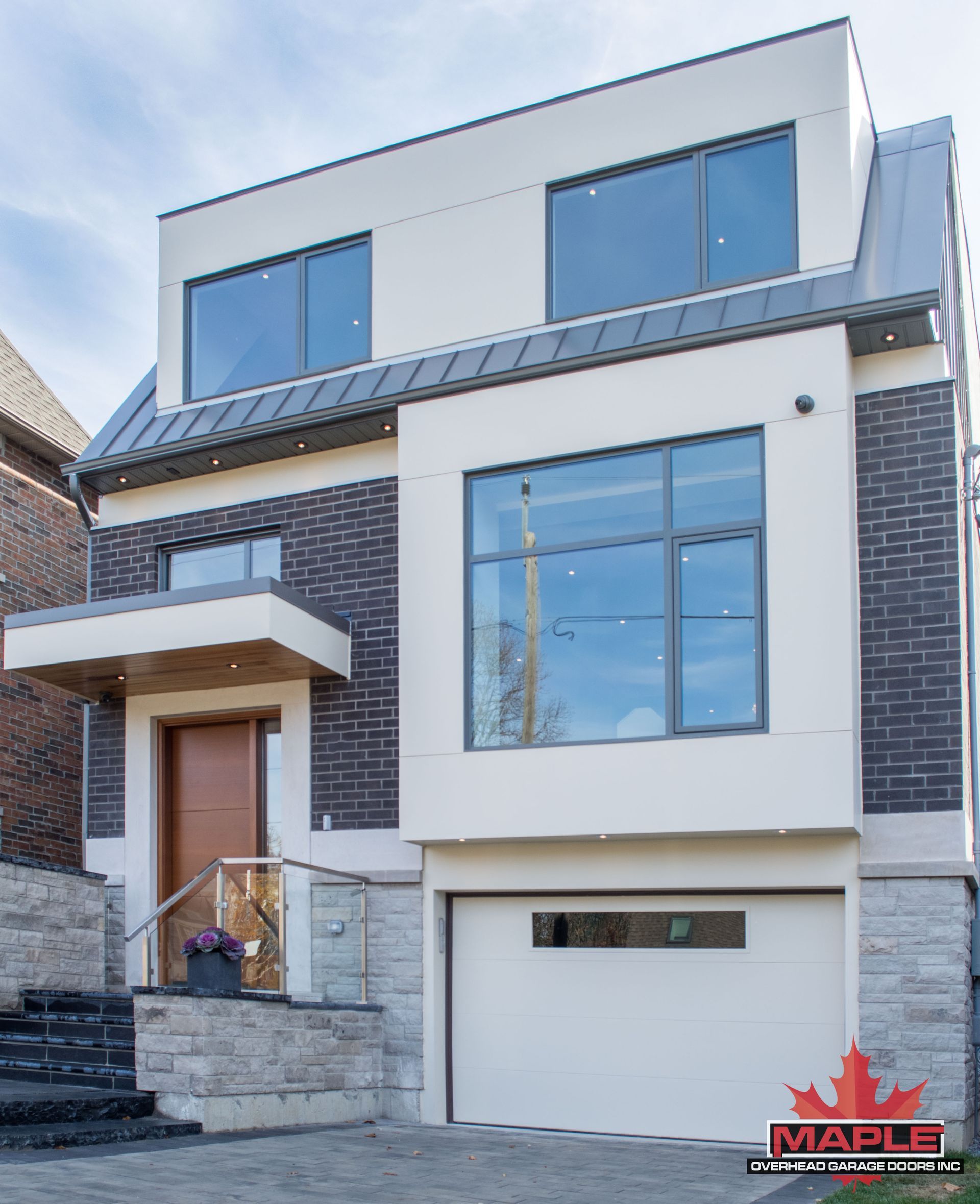 A large white house with a brick facade and a white garage door