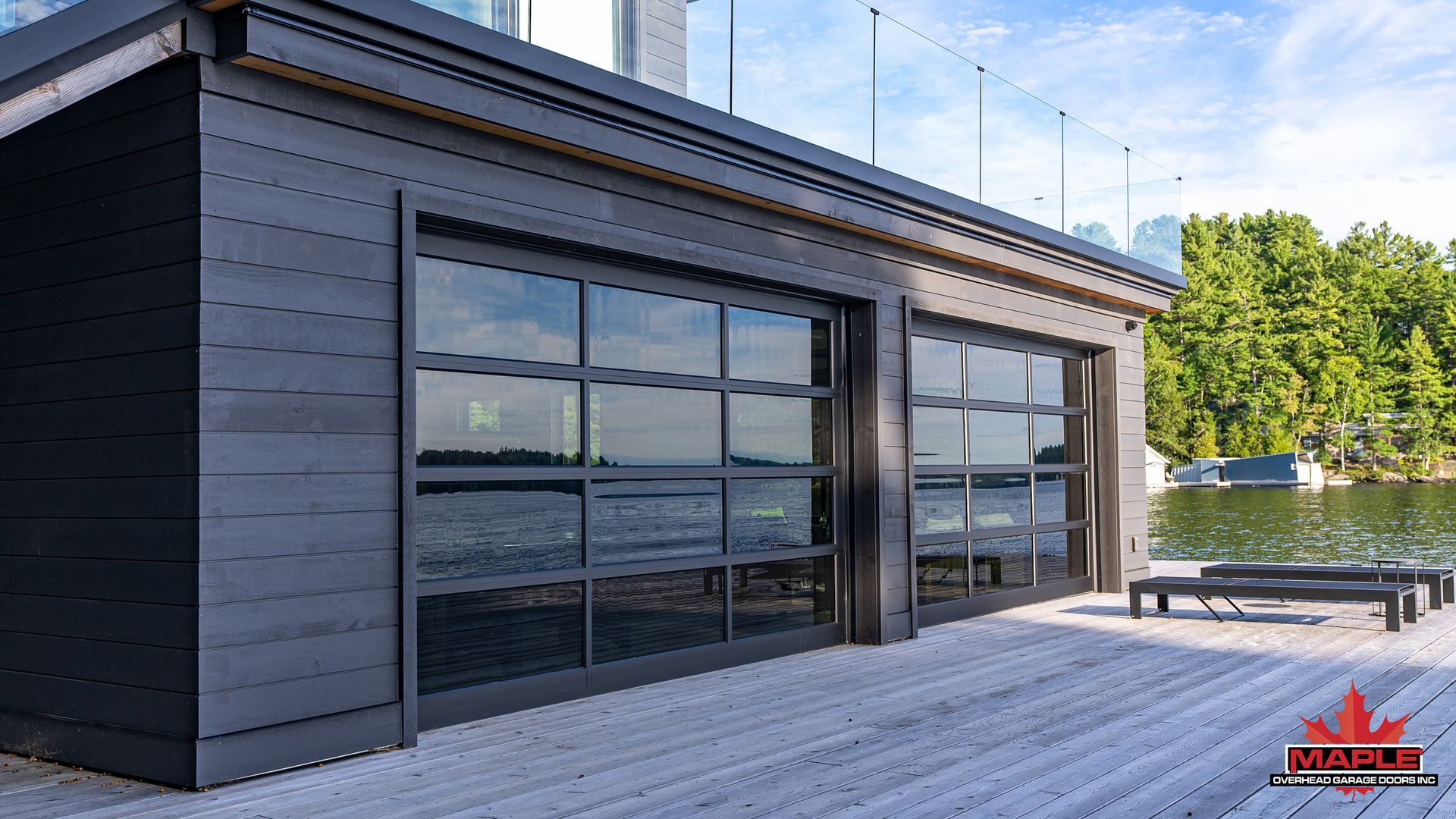 A black building with a lot of windows is next to a body of water.