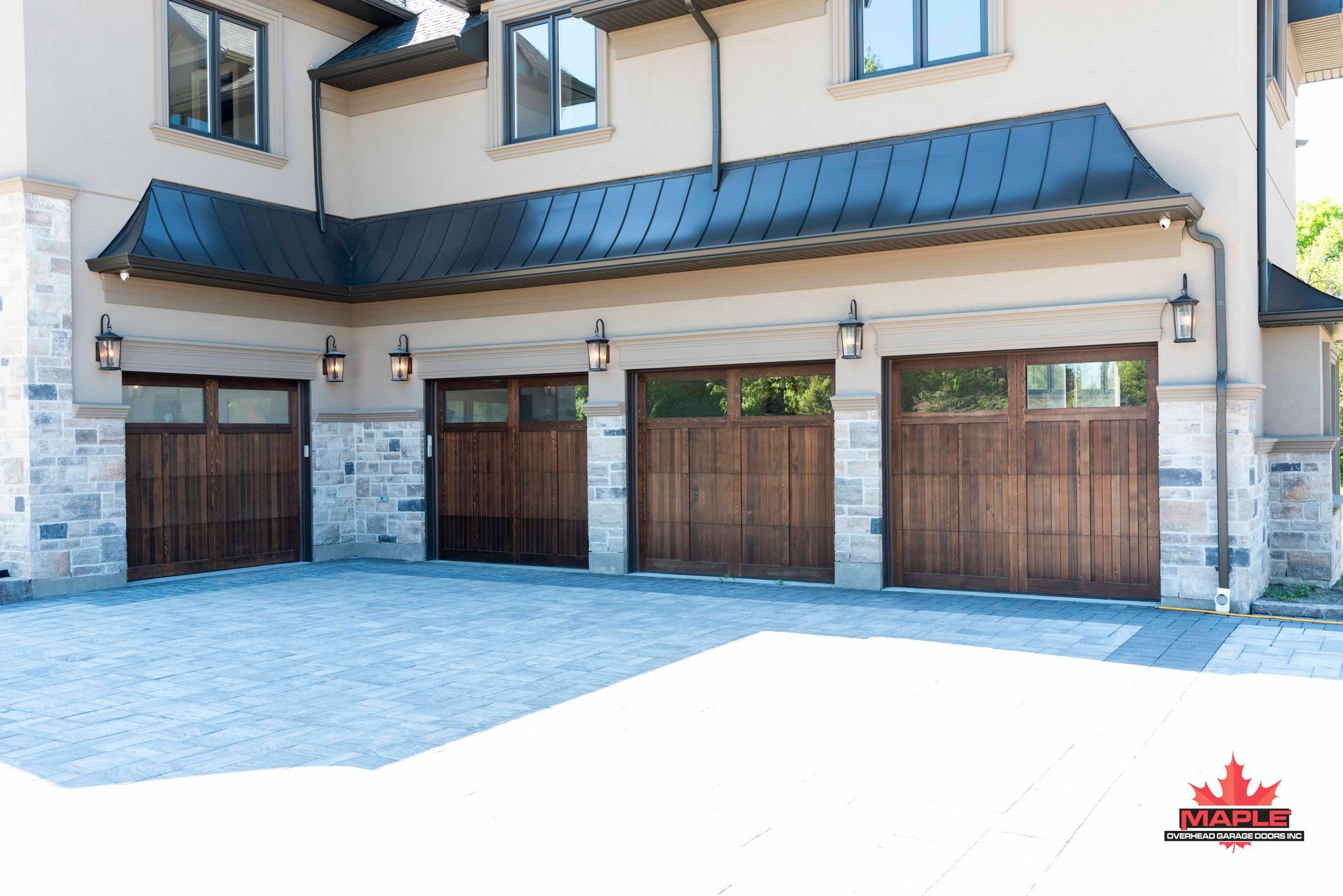 A large house with wooden garage doors and a black roof