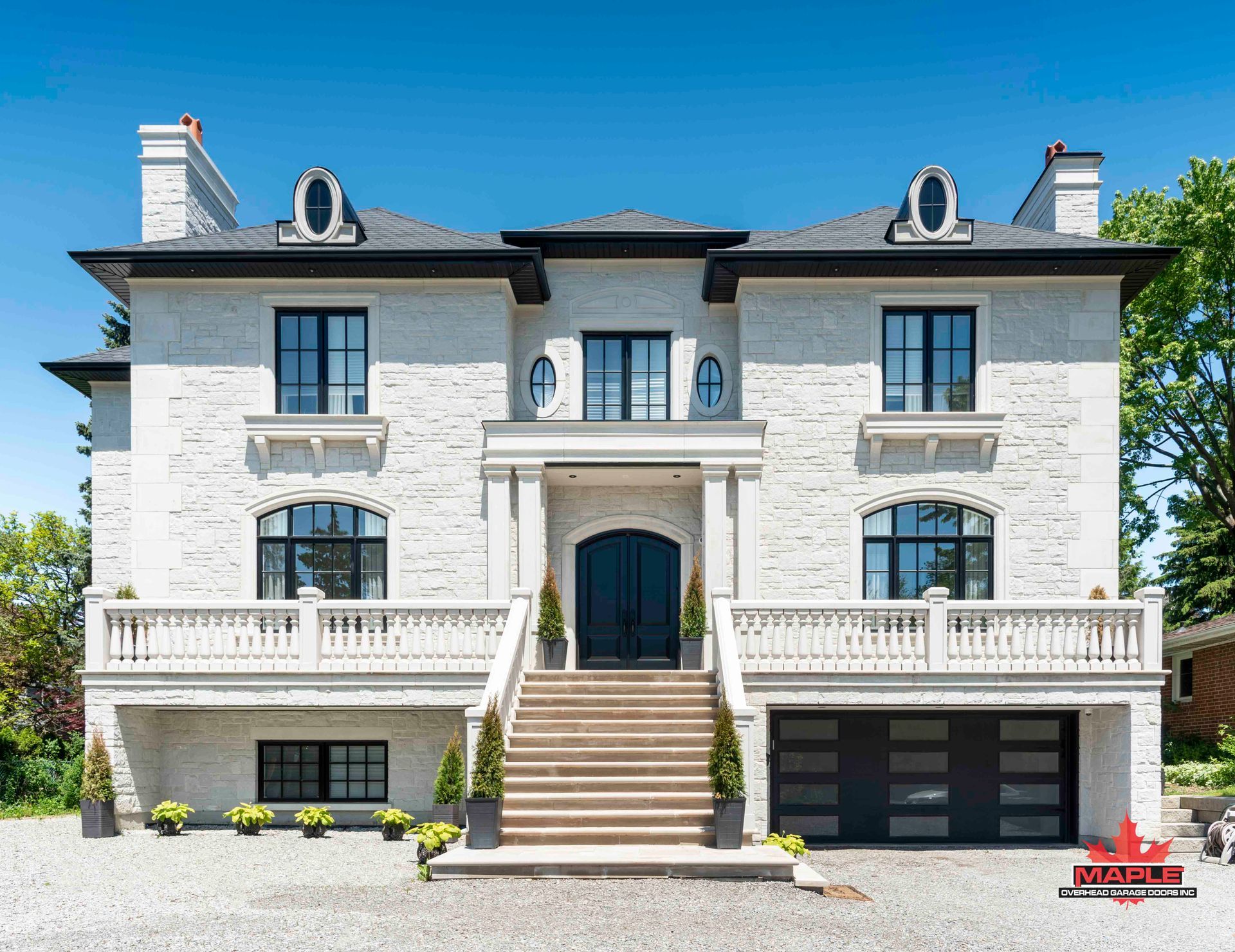 A large white house with stairs leading up to the front door.