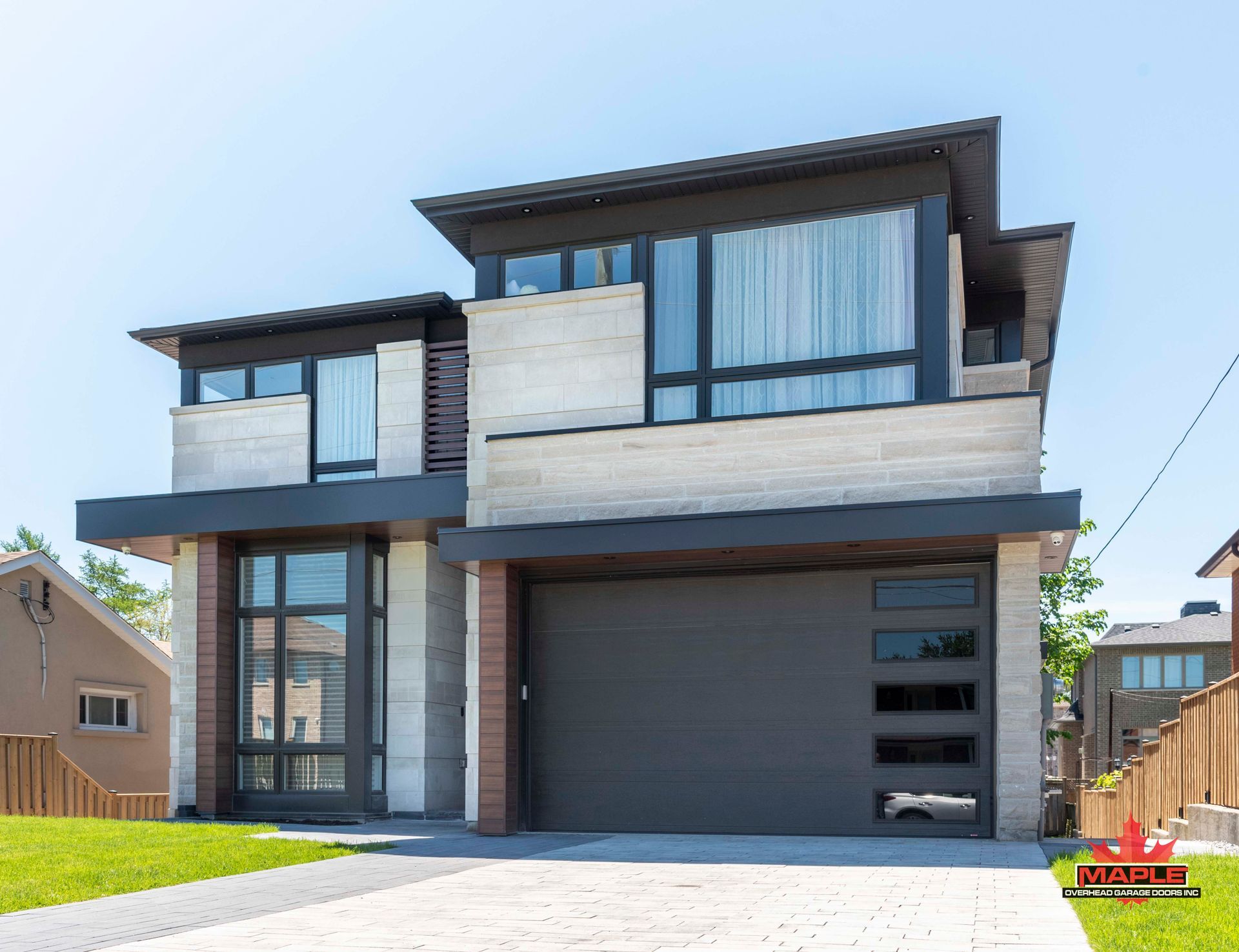 A modern house with a large garage door and a lot of windows.