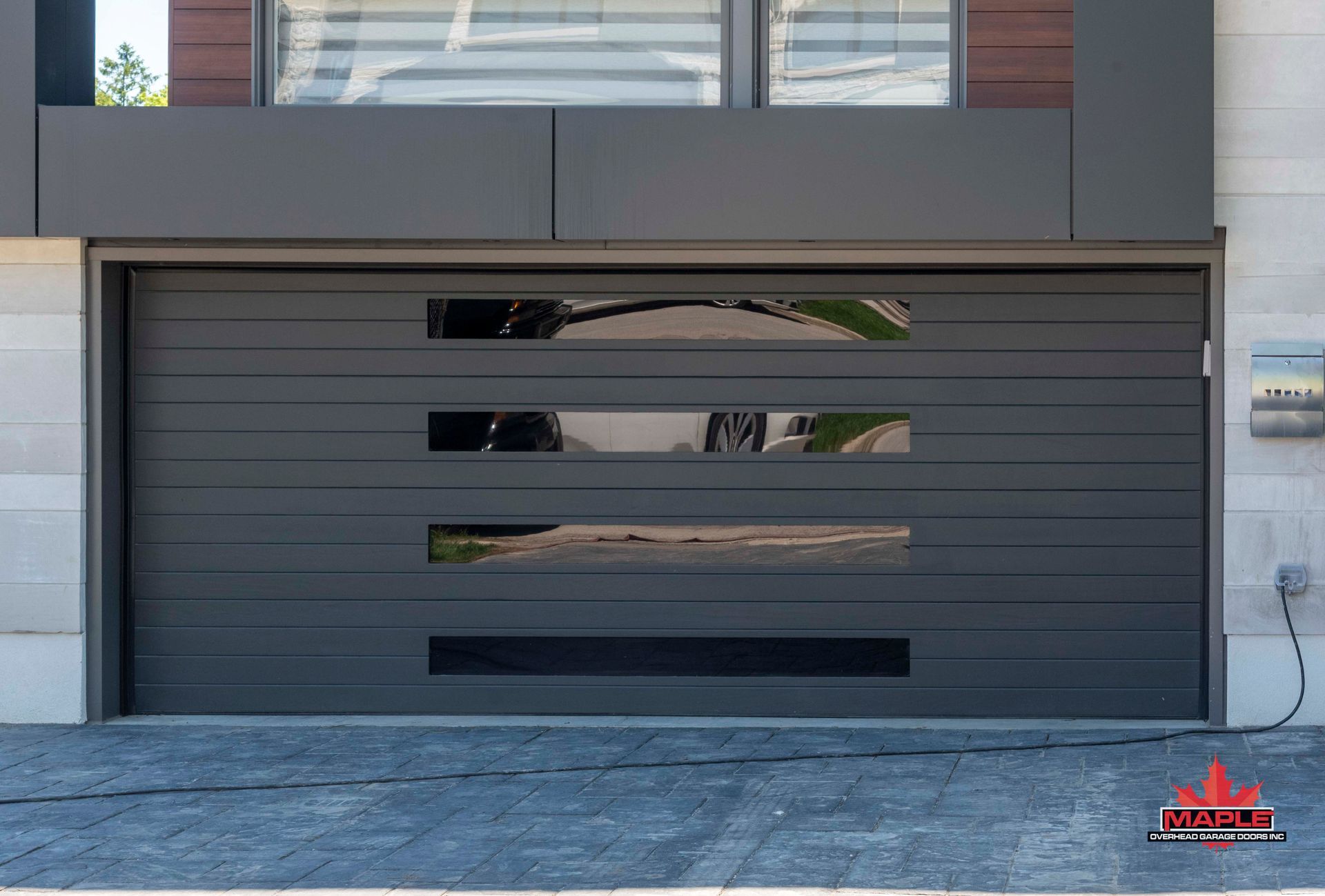 A black garage door with a reflection of a car in it