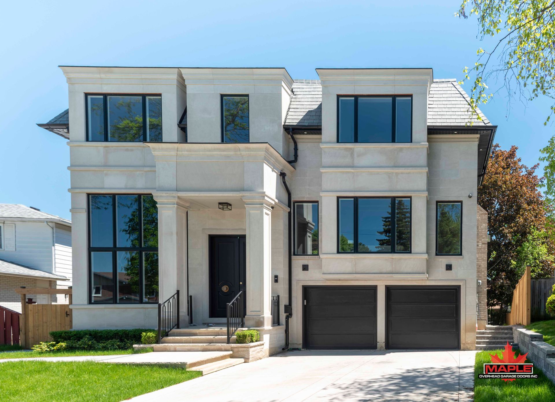 A large white house with two garages and a lot of windows.