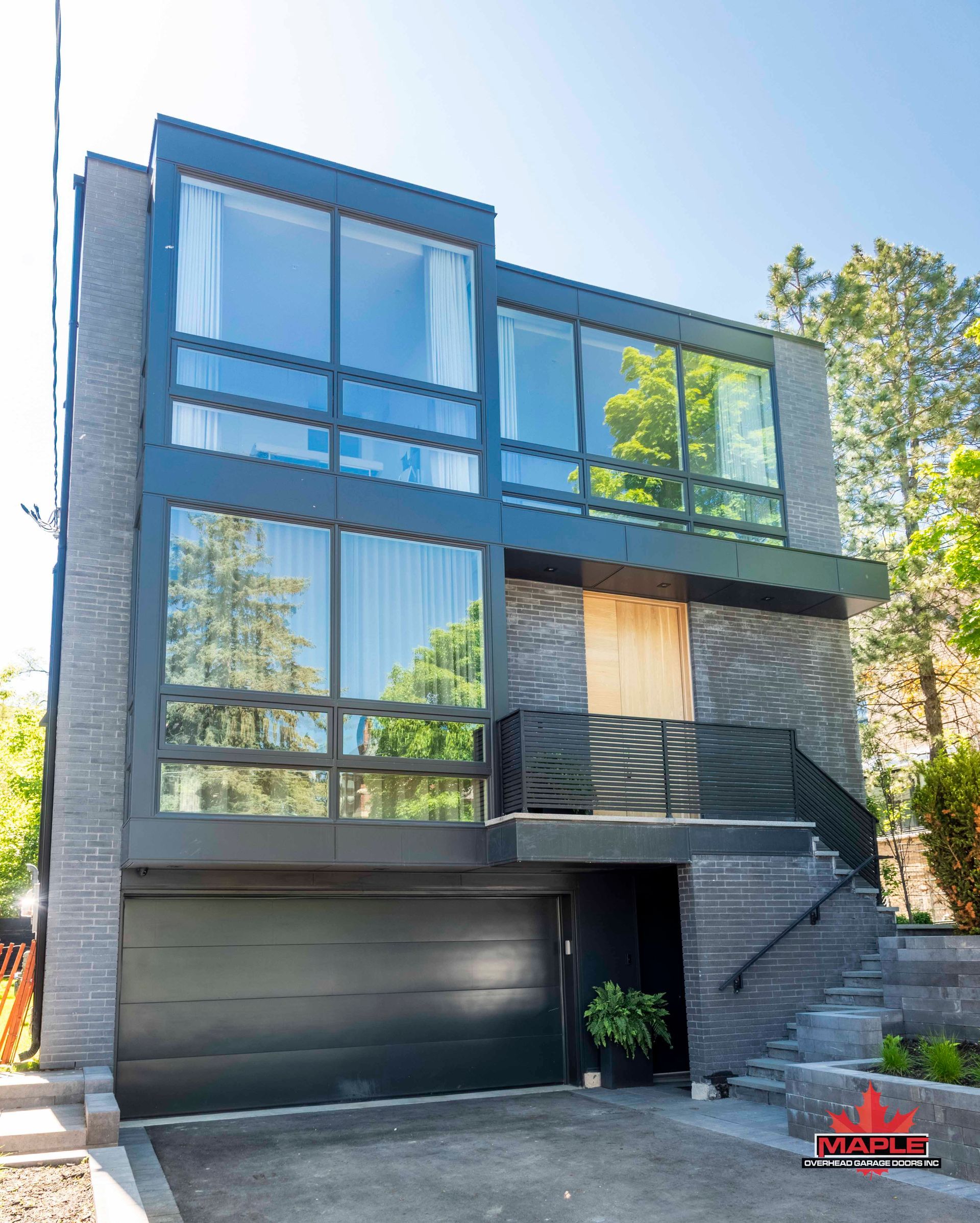 A modern house with a black garage door and stairs