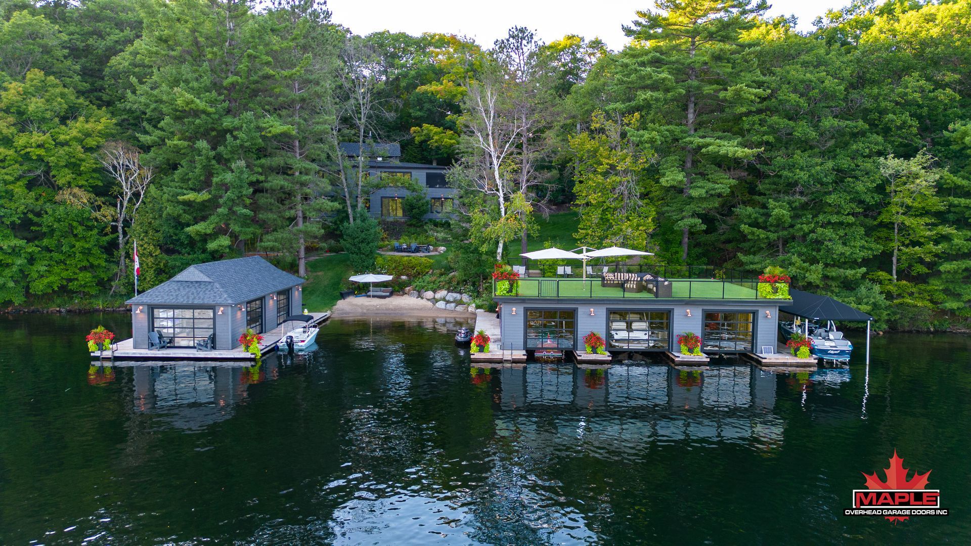 An aerial view of a house floating on top of a lake surrounded by trees.