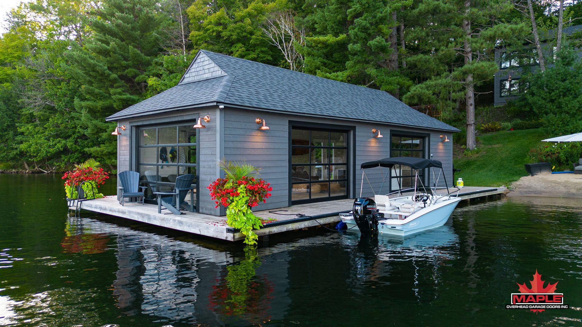 A boat is docked in front of a house on a dock on a lake.