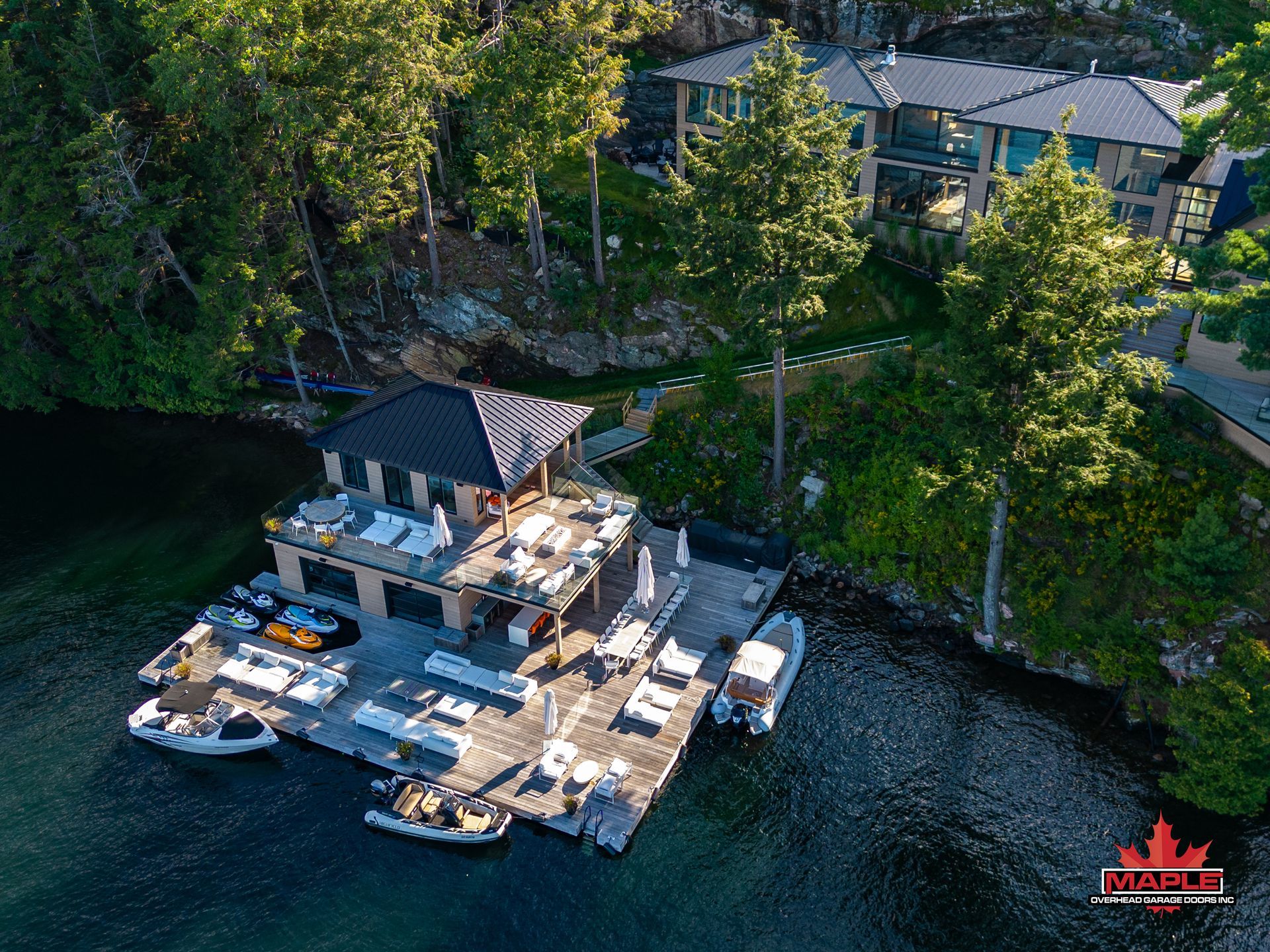An aerial view of a dock with boats and a house in the background.