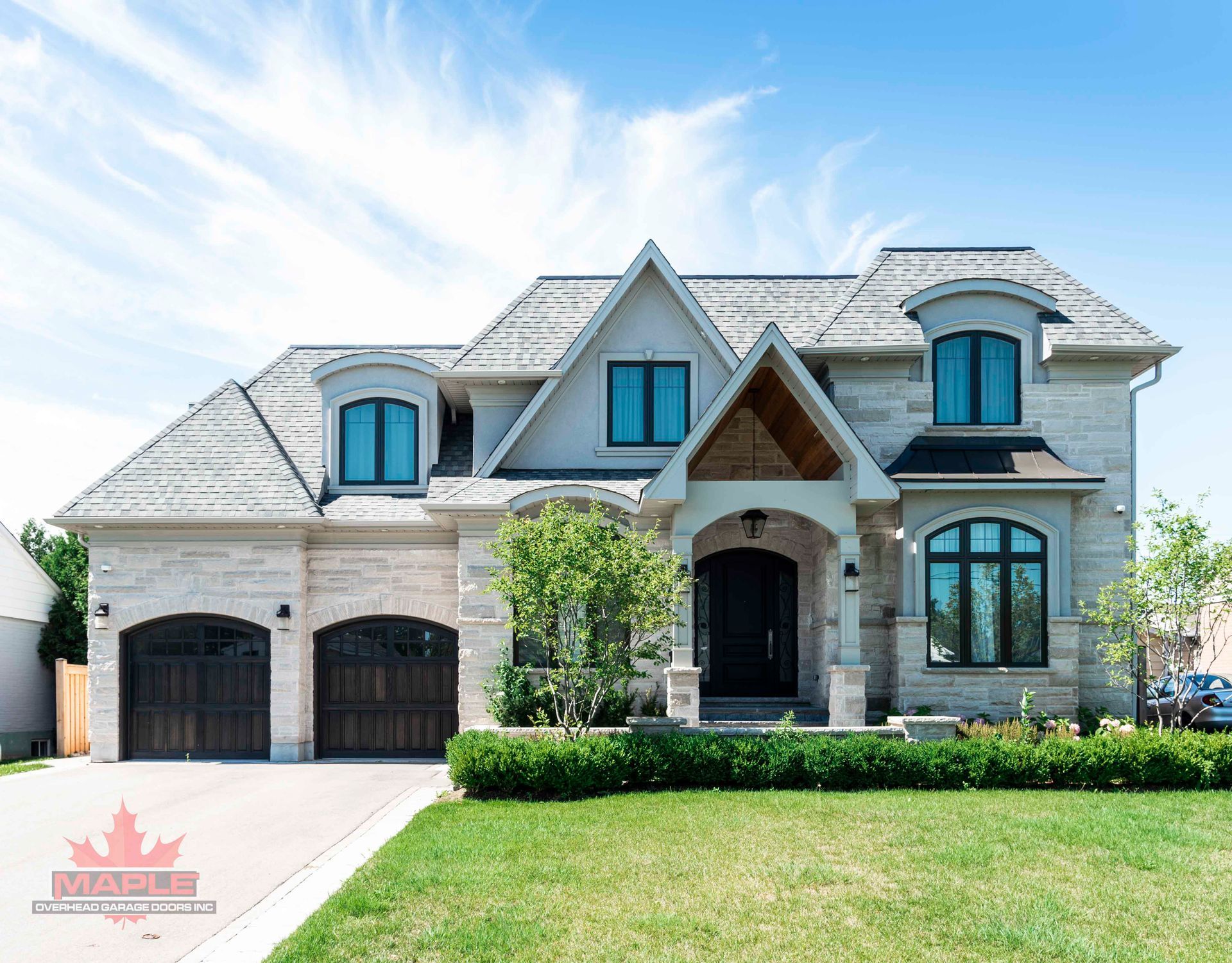 A large house with a lot of windows is sitting on top of a lush green lawn.