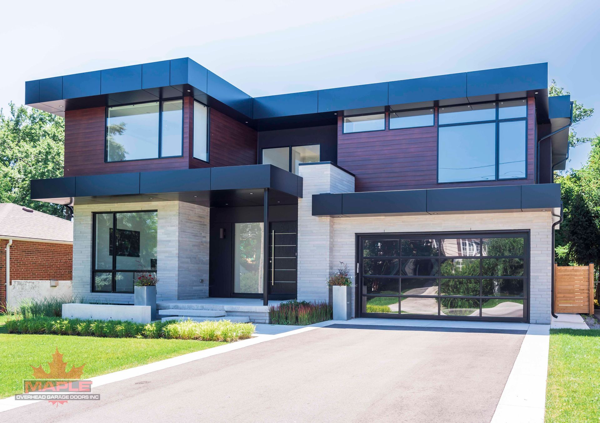 A modern house with a lot of windows and a driveway