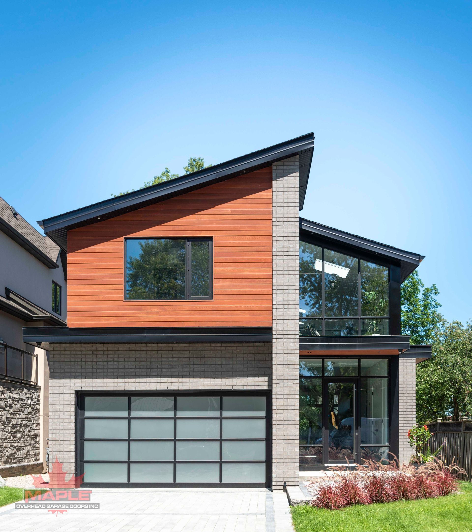 A modern house with a large garage door and a large window.