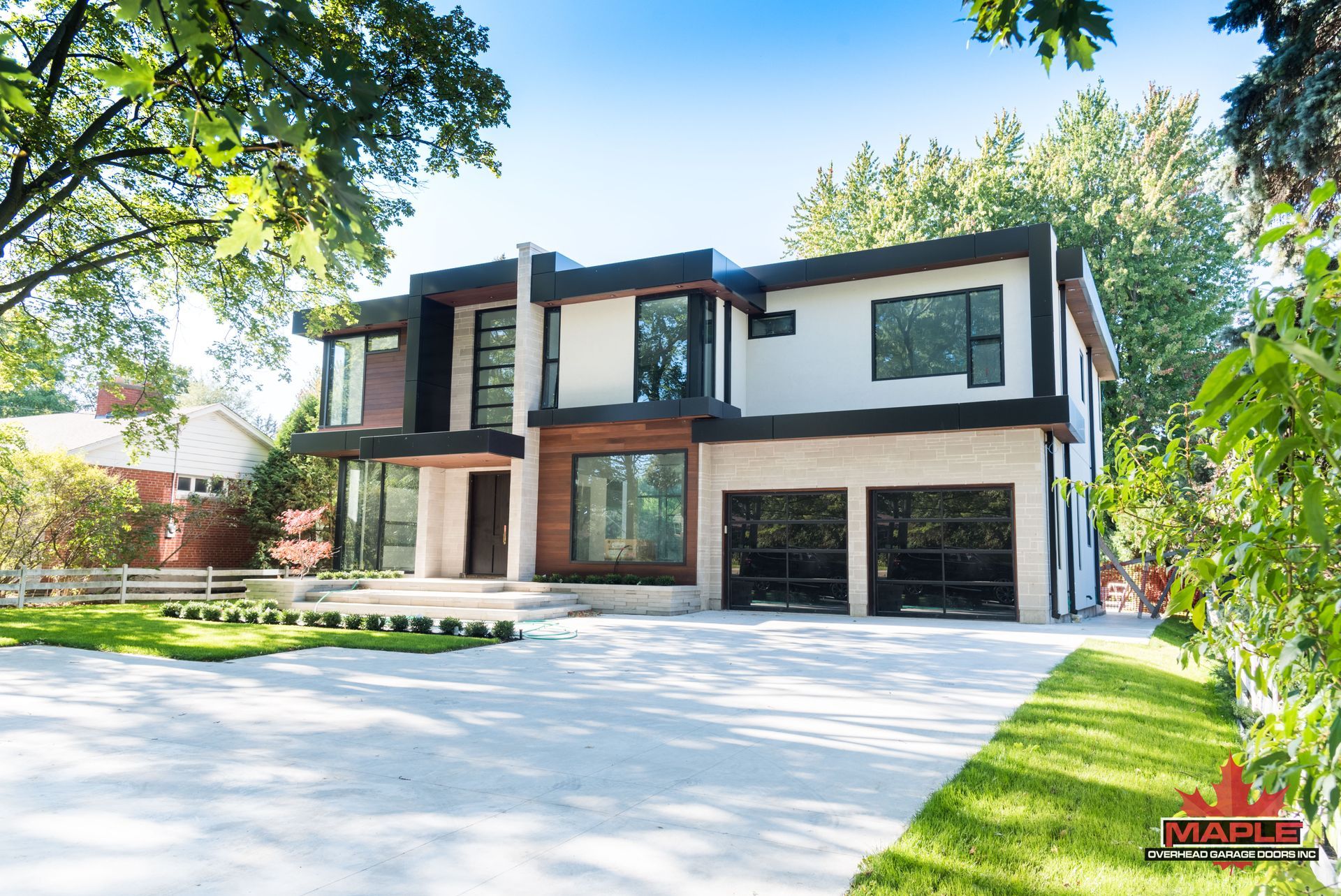 A large house with a lot of windows is surrounded by trees and grass.
