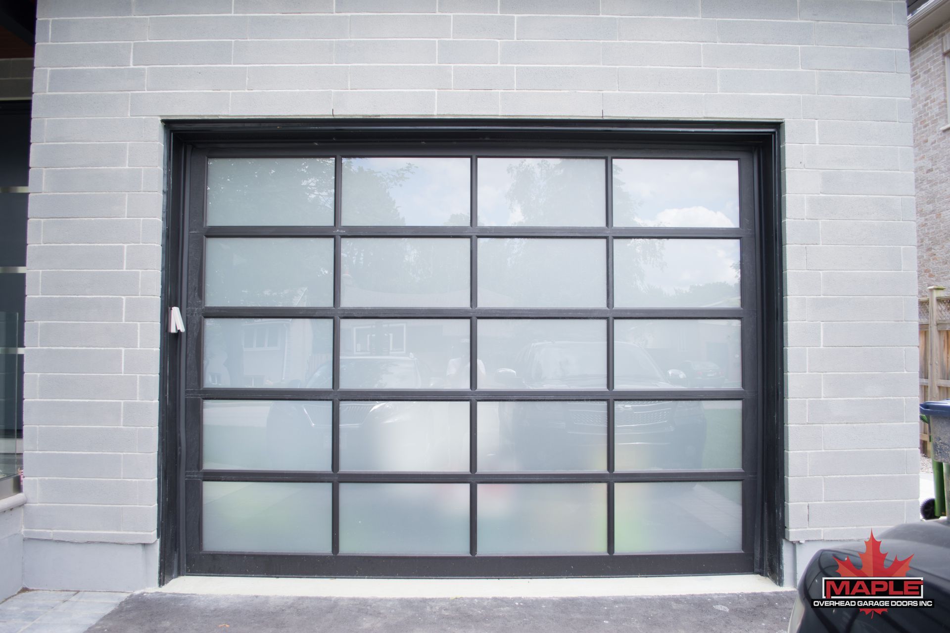 A garage door with a lot of windows and a car parked in front of it.