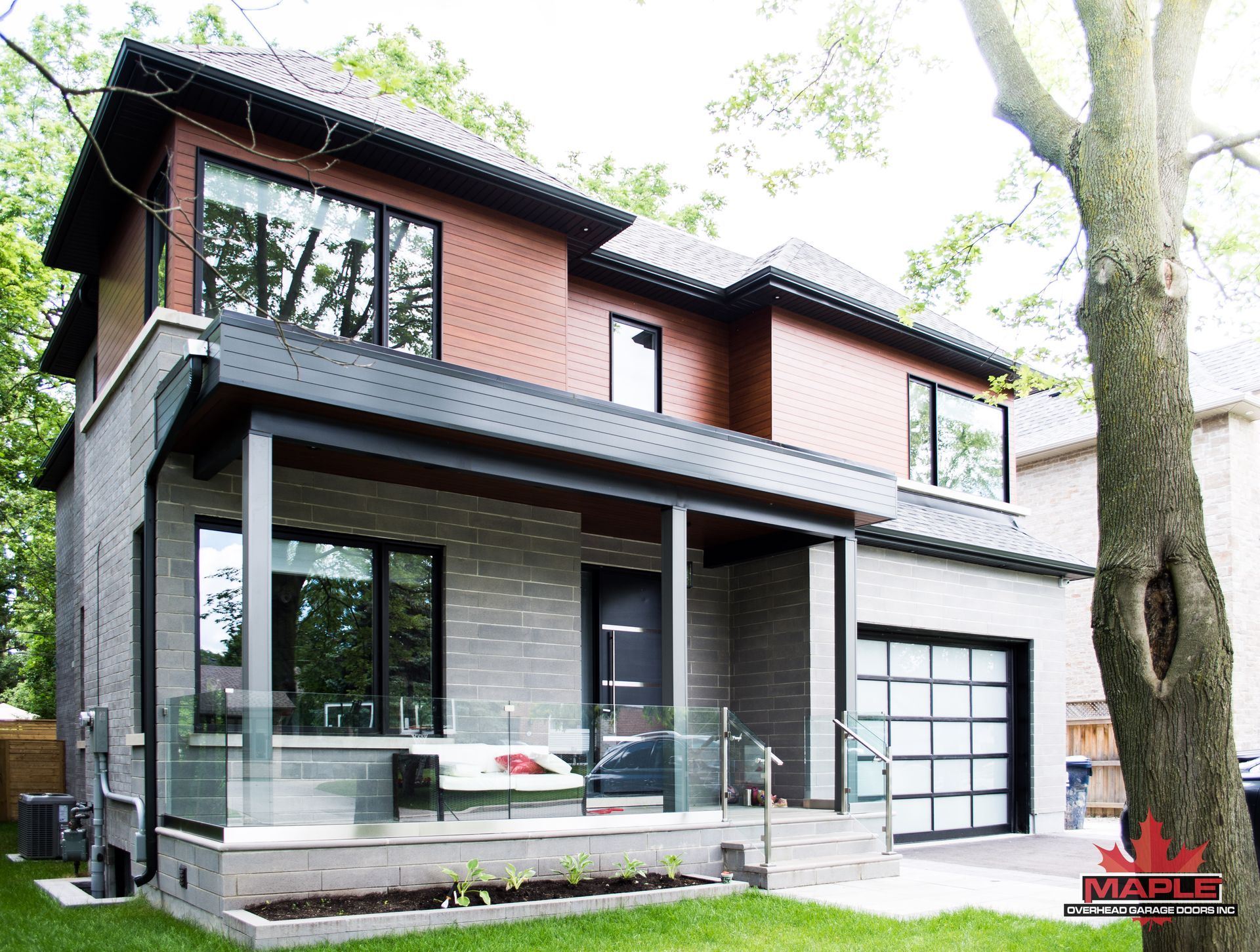 A large house with a large porch and a tree in front of it