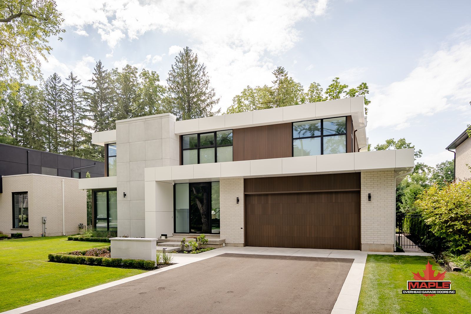 A modern house with a large garage and a driveway leading to it.