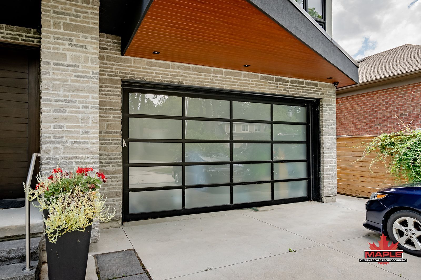 A car is parked in front of a large garage door.