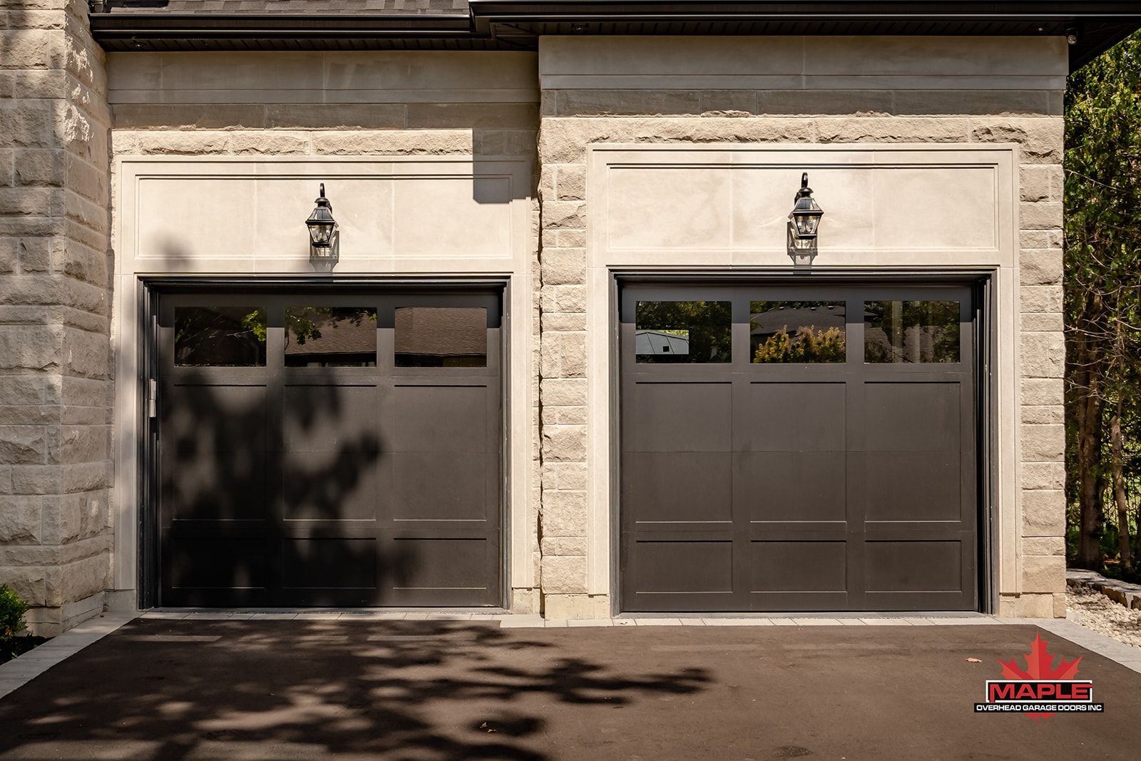 There are two garage doors on the side of a house.
