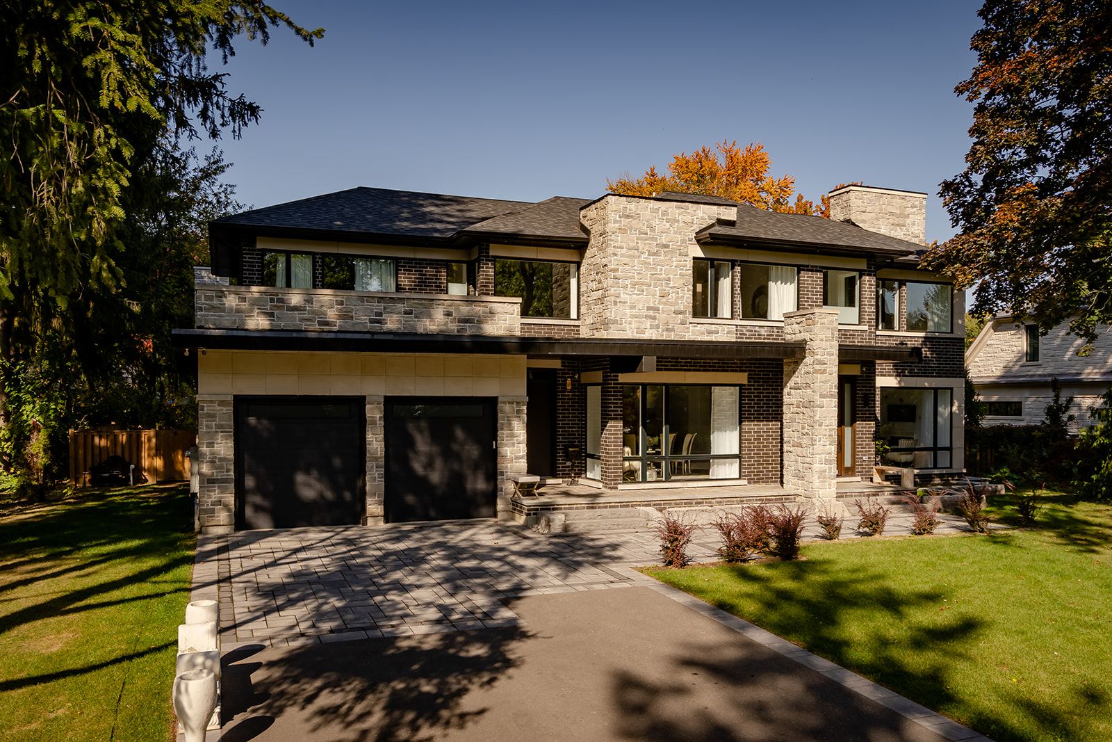 A large house with two garages and a driveway in front of it.