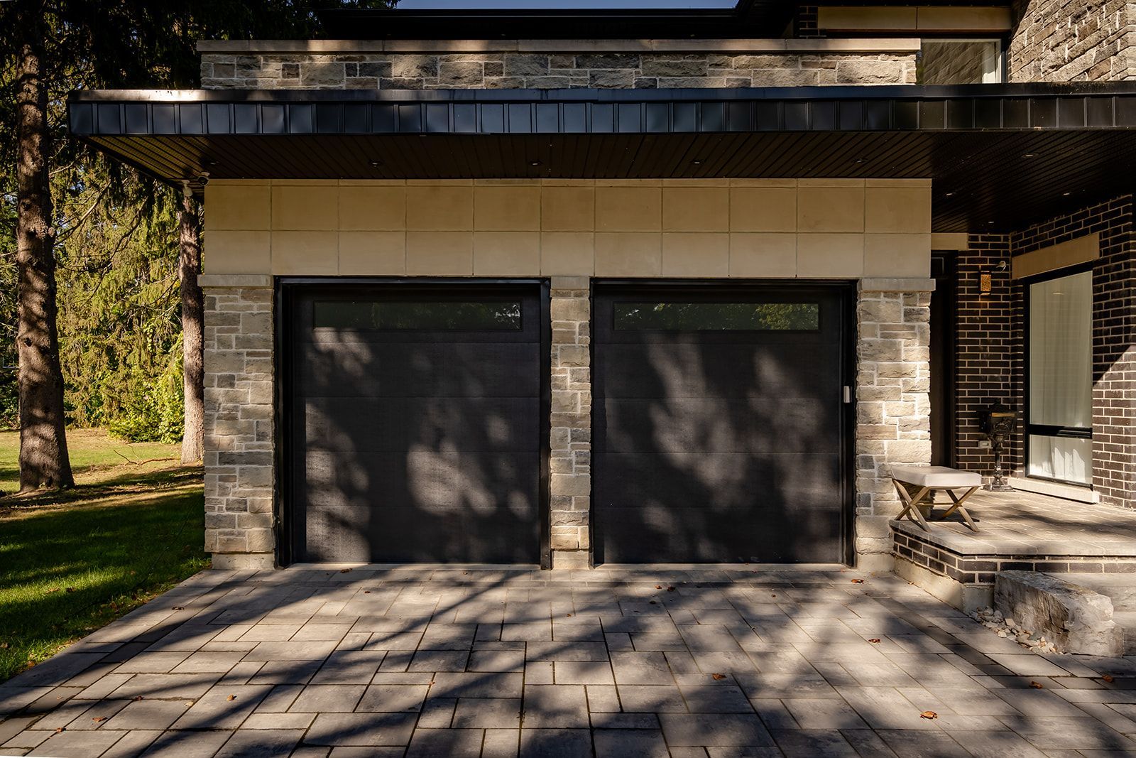 There are two garage doors on the side of a house.