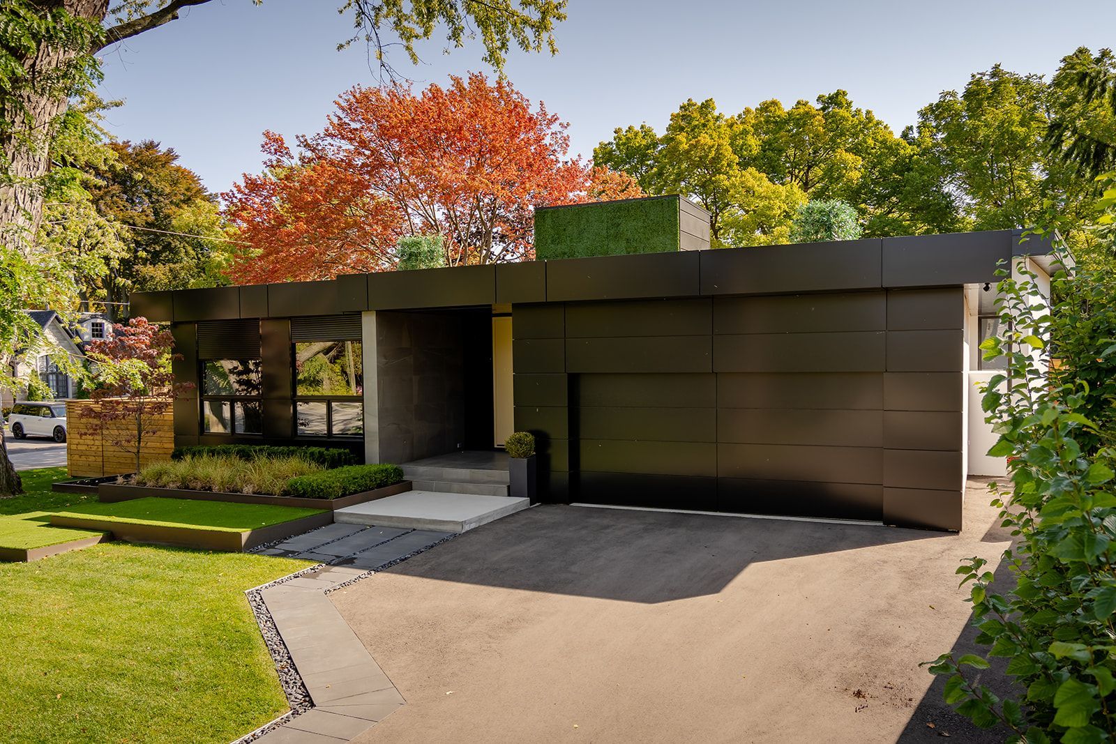 A modern house with a black garage door and a driveway