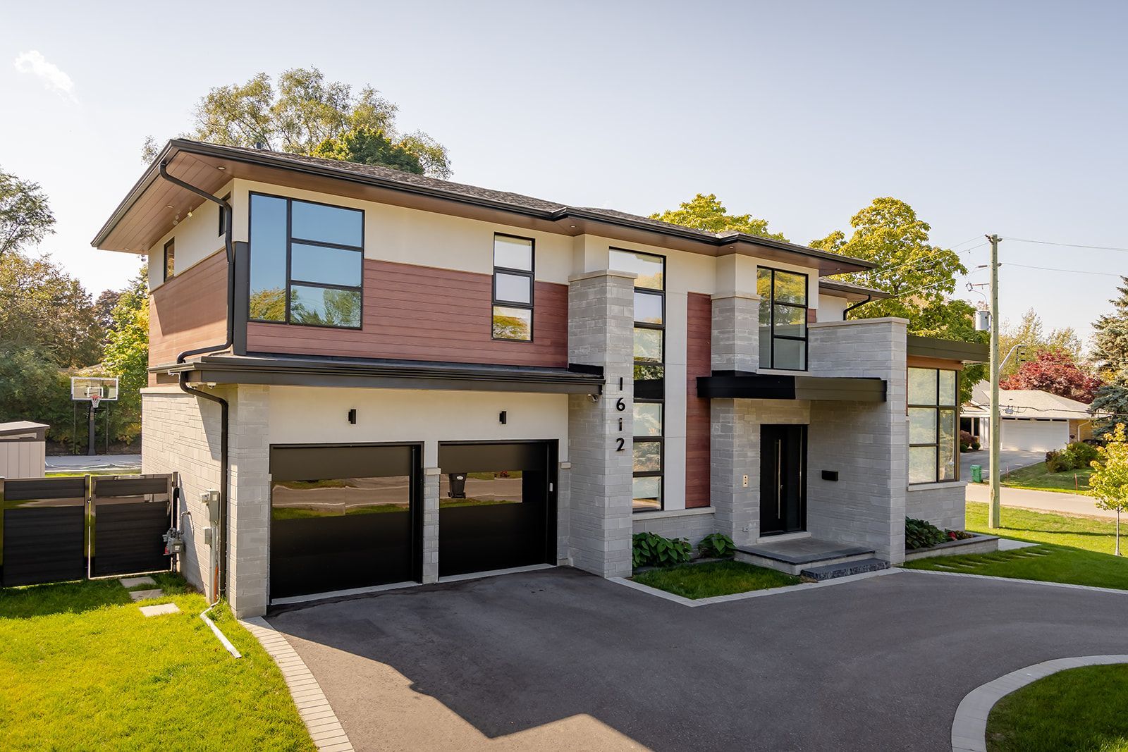 A large house with two garages and a driveway in front of it.