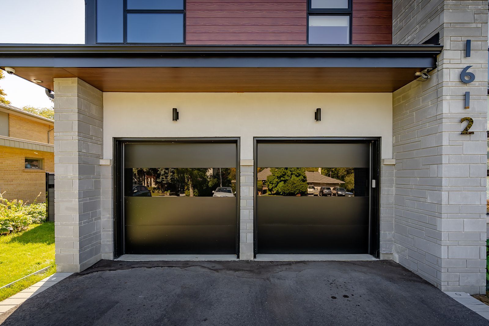 A house with two black garage doors and a driveway