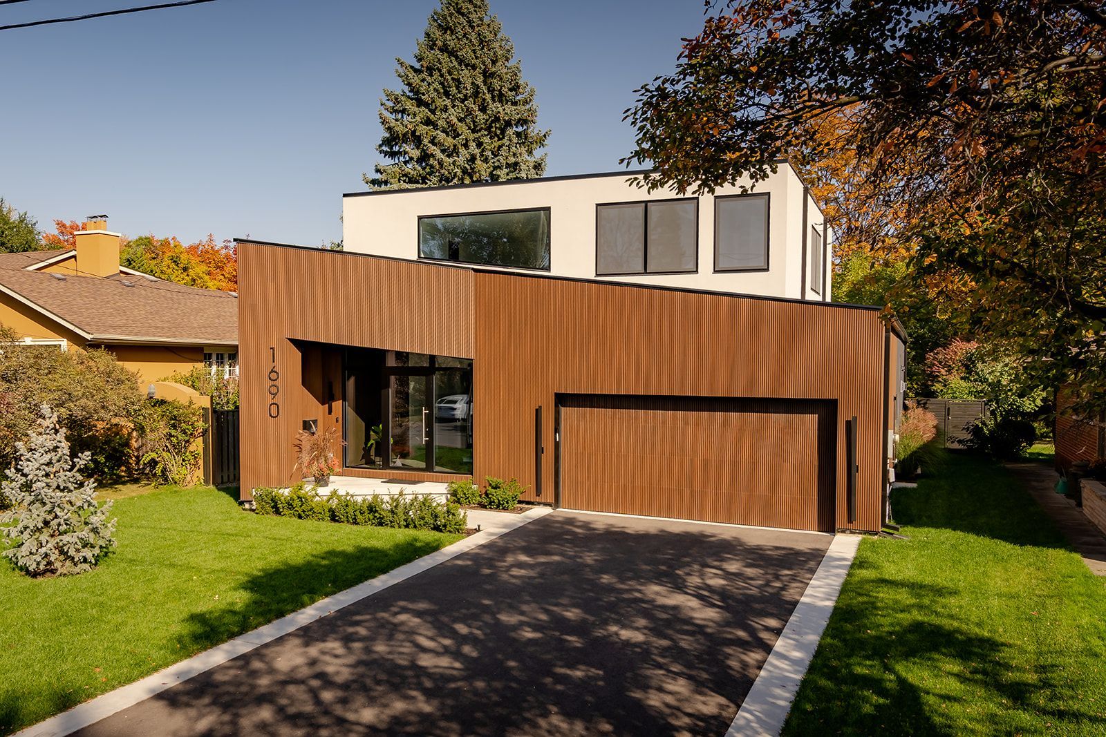 A modern house with a wooden garage door and a driveway