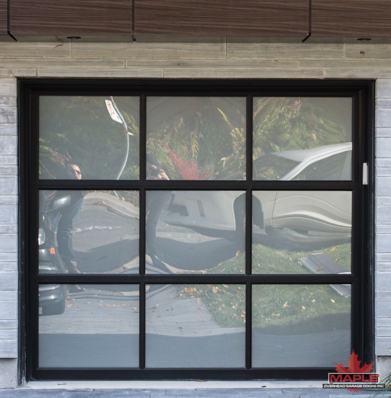 A black garage door with a maple leaf on it