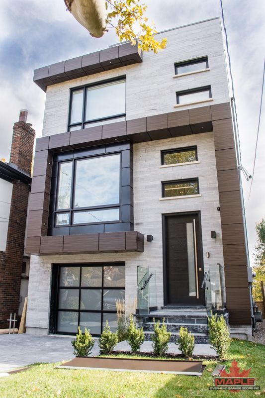 A modern house with a lot of windows and a garage door