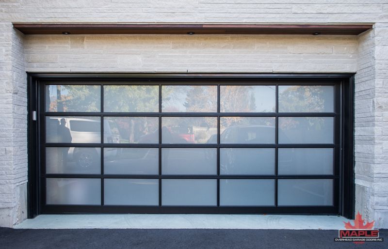 A garage door with a lot of windows and a car parked in front of it.