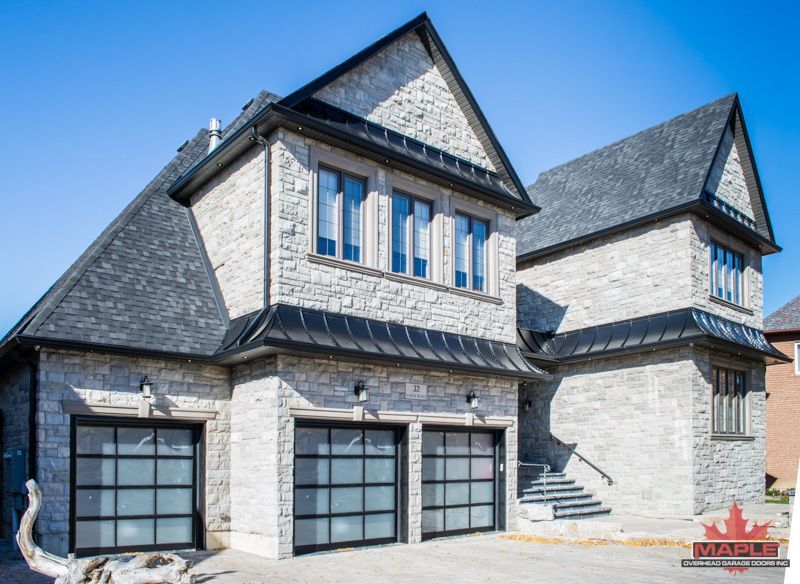 A large house with two garage doors and stairs.