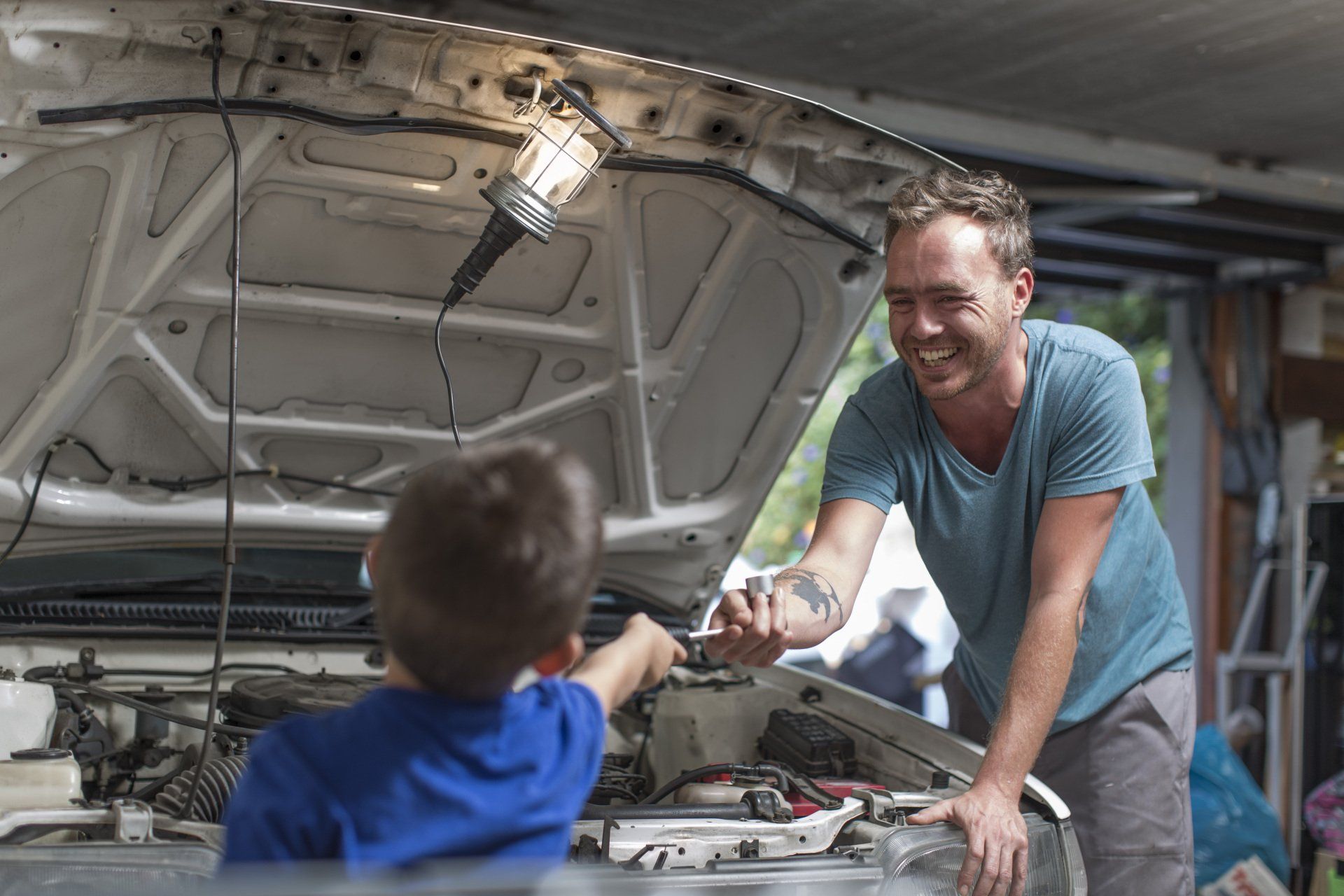 son and dad working in a garage