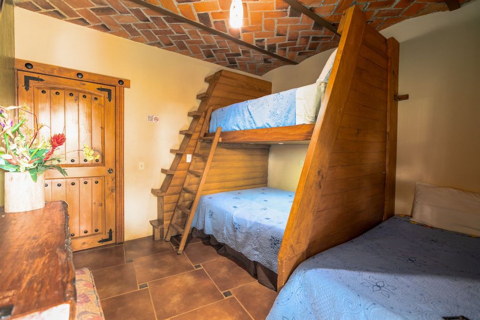 Un dormitorio con dos literas y una escalera.