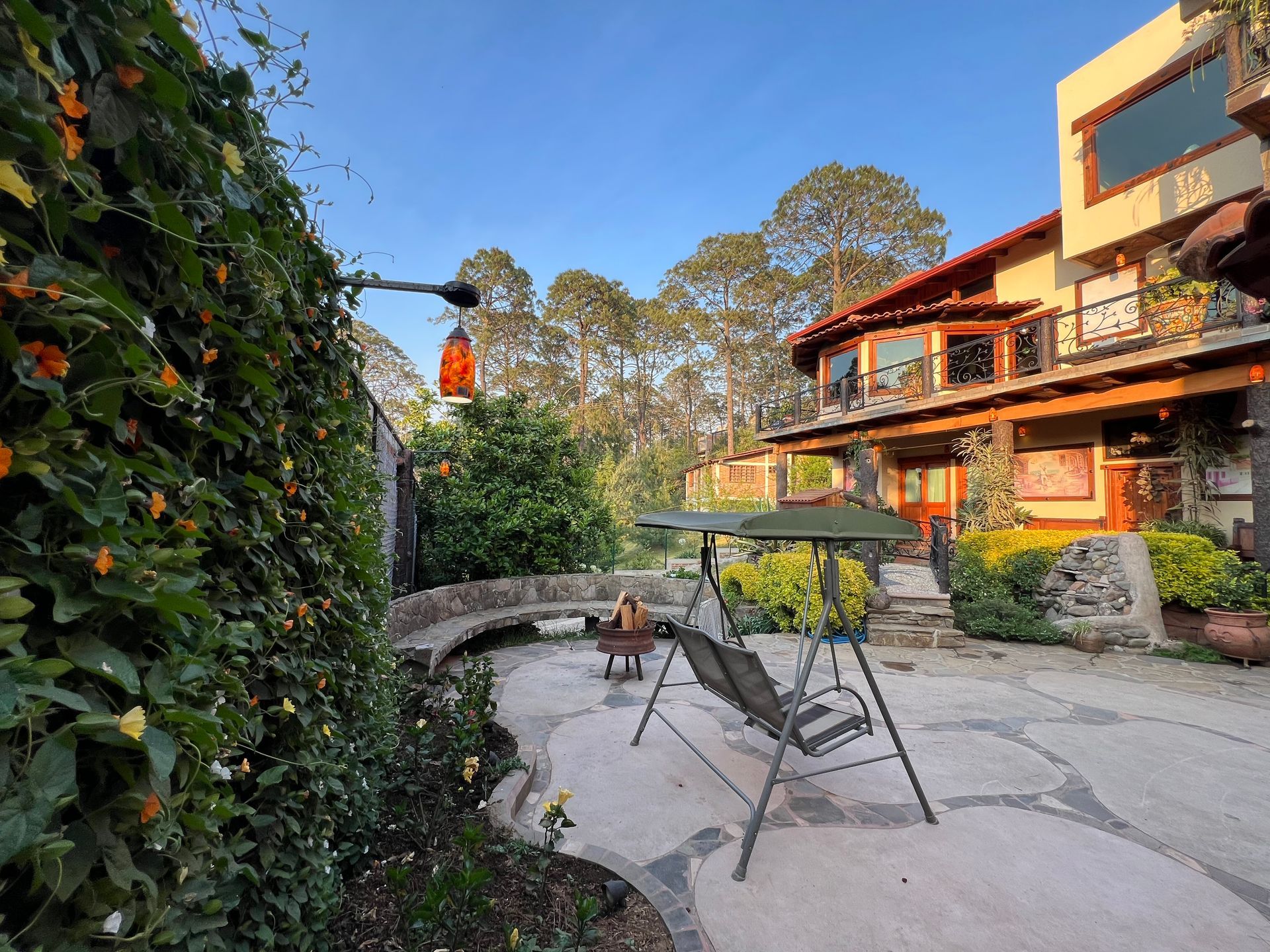 Un columpio está sentado en un patio frente a una casa.