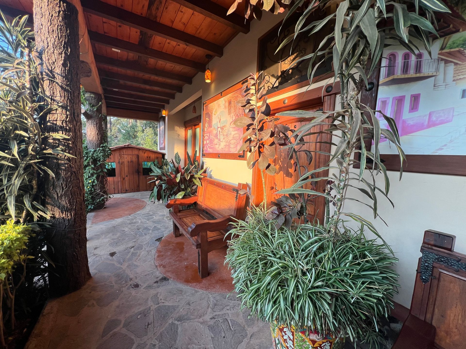 Un porche con un banco y plantas delante de un edificio.