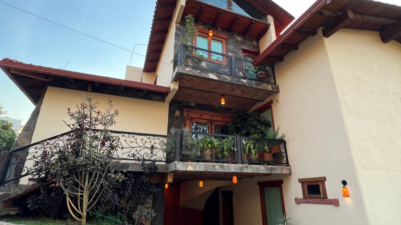 Una casa grande con balcón y techo rojo.